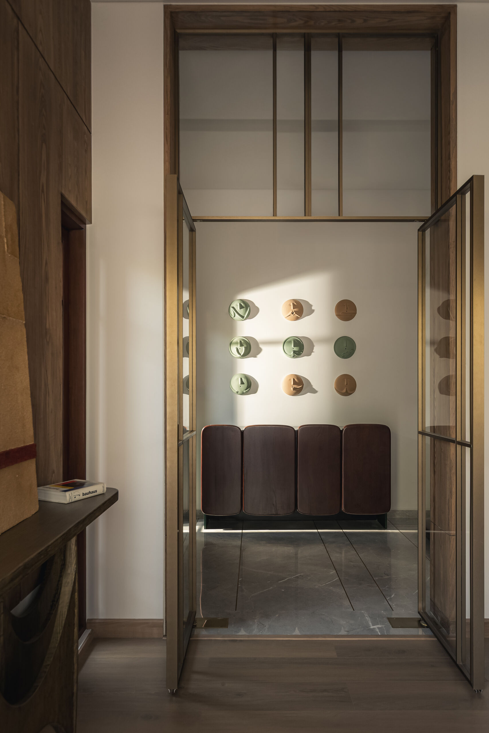 The entry sets the tone for everything that follows. There’s no harsh contrast or dramatic statement here. Instead, the materials speak first. Warm wood surfaces and sleek metal elements begin to introduce the palette that carries through the entire home.