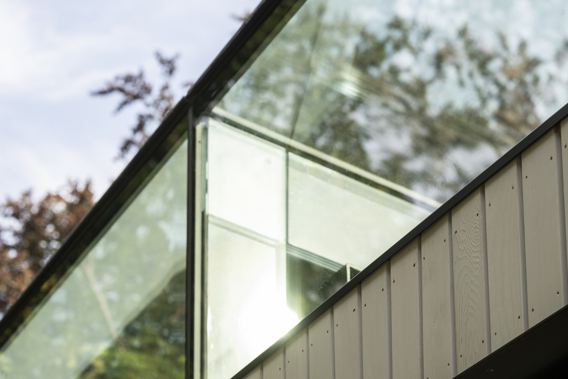 A glazed roof edge brings in views of the sky and garden, adding light and a new sense of openness to the interior.