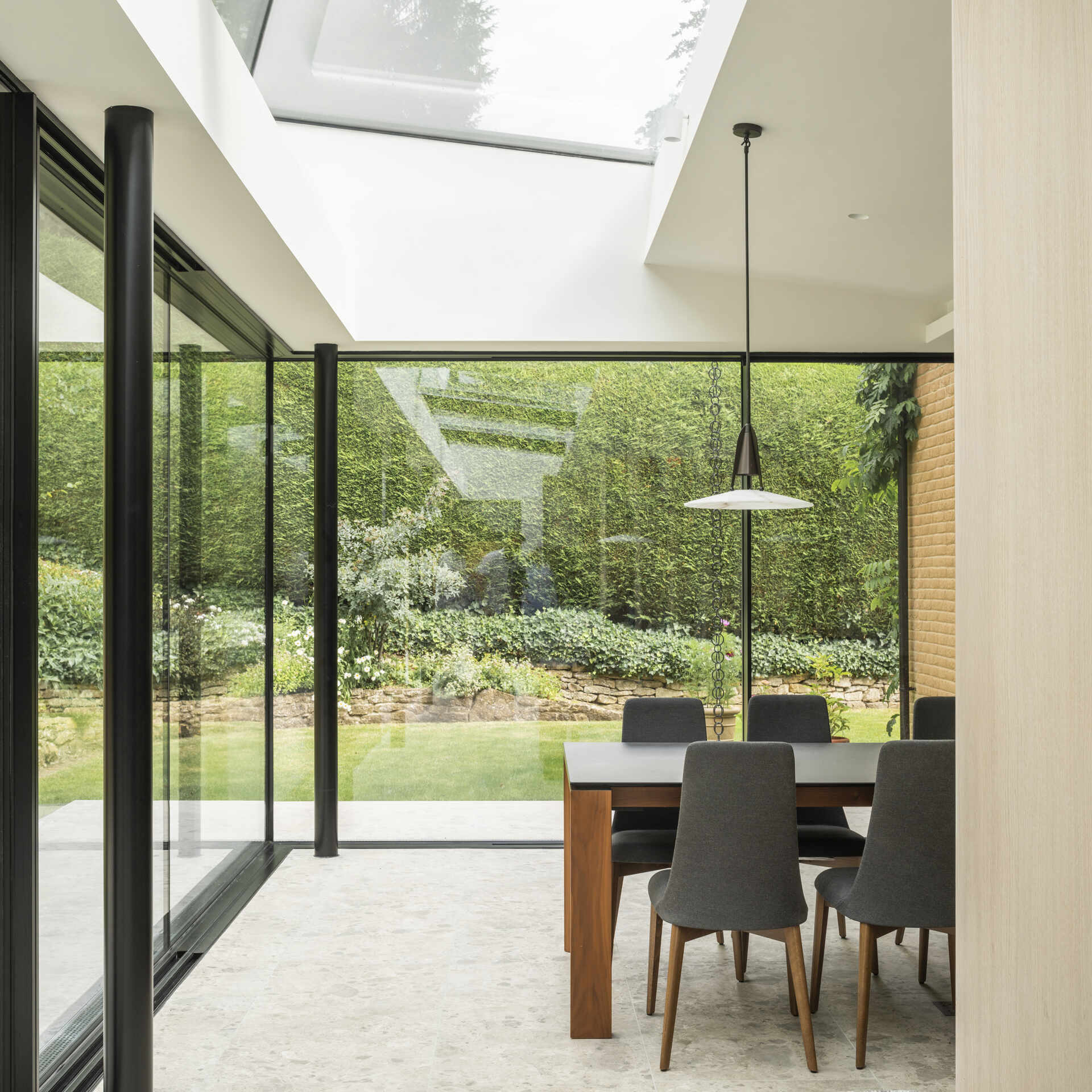 A modern dining room with floor-to-ceiling windows.