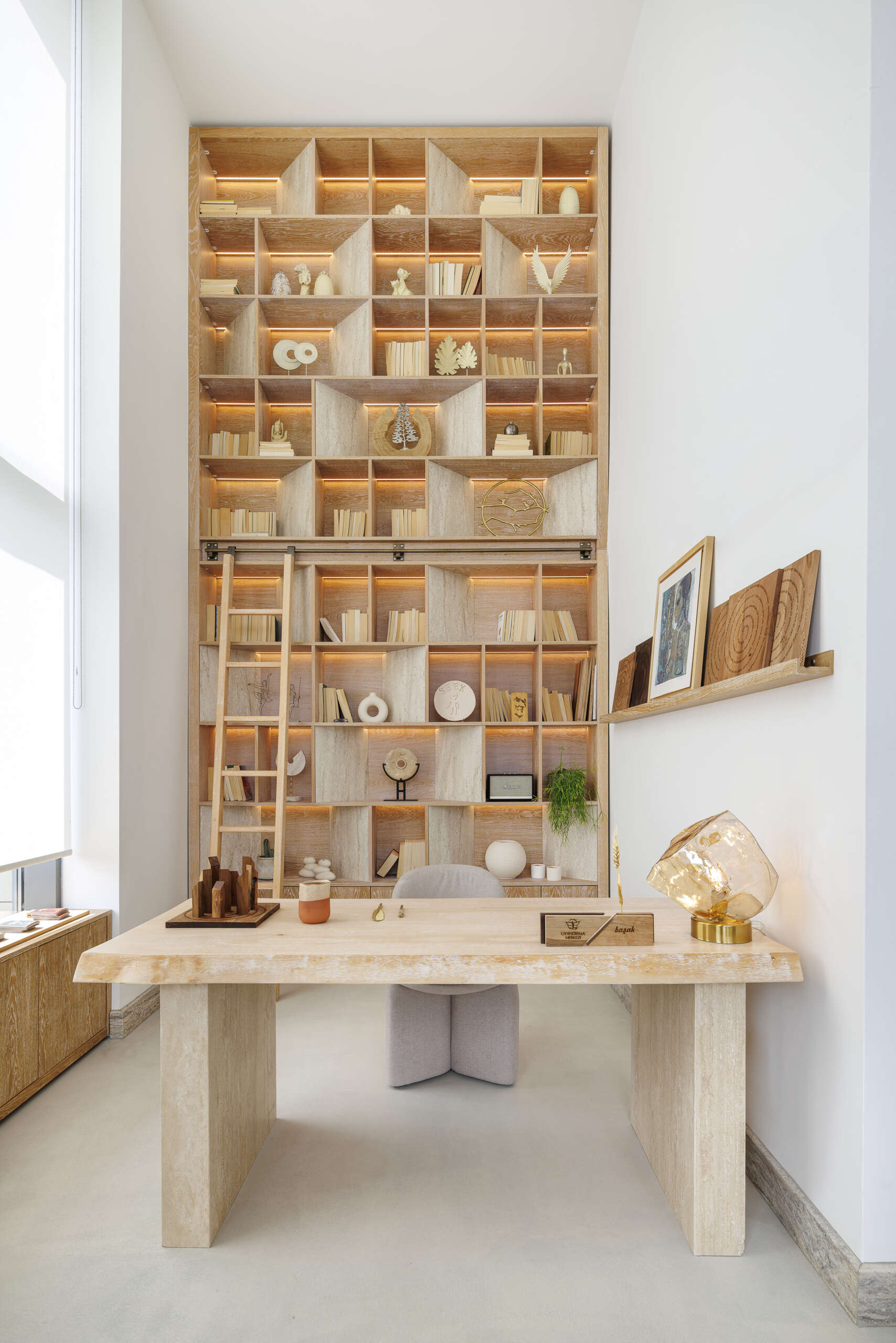 In this loft apartment, a full-height wood library with lighting, becomes a focal point, pointing to knowledge as an ongoing process, something built step by step over time.