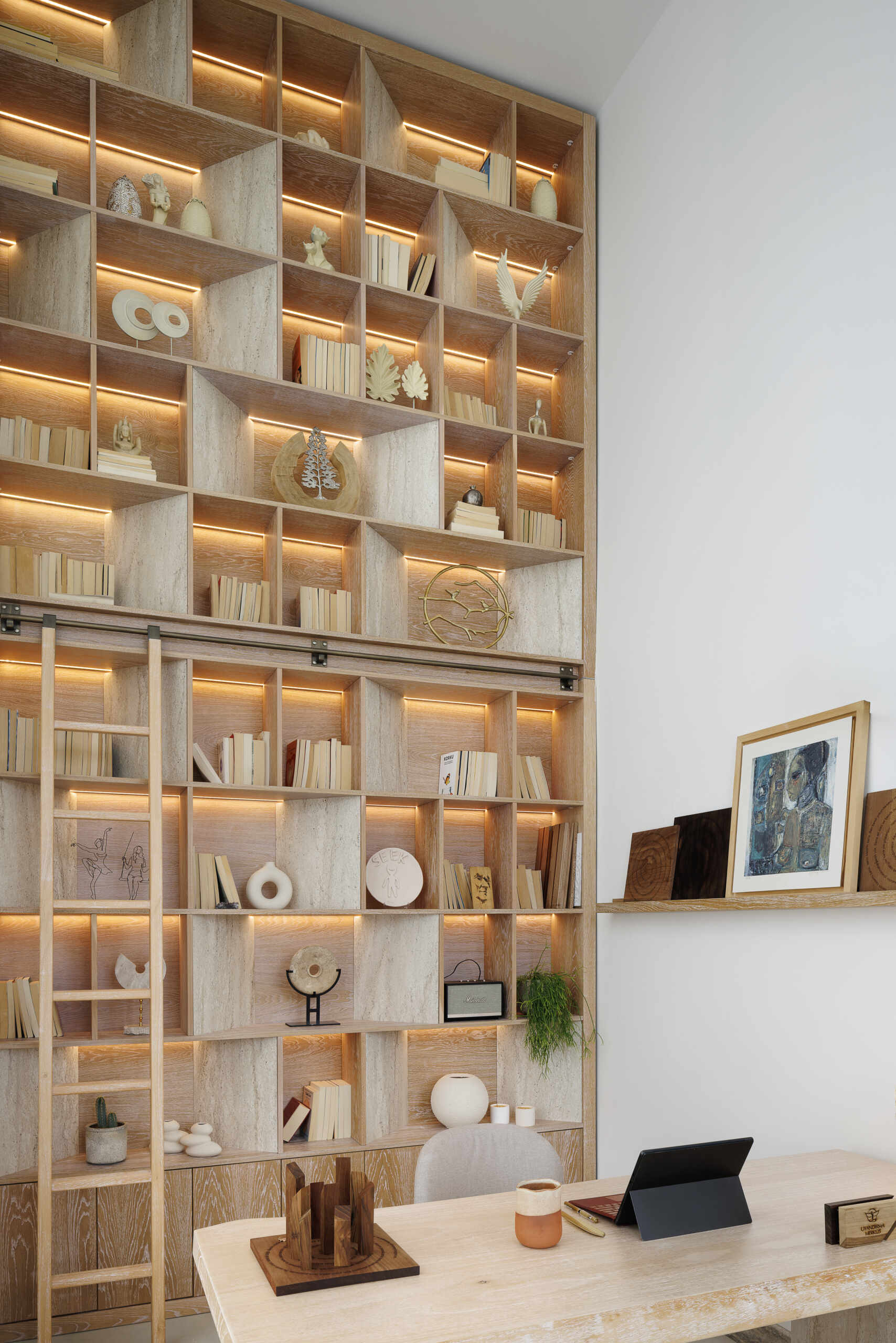 In this loft apartment, a full-height wood library with lighting, becomes a focal point, pointing to knowledge as an ongoing process, something built step by step over time.