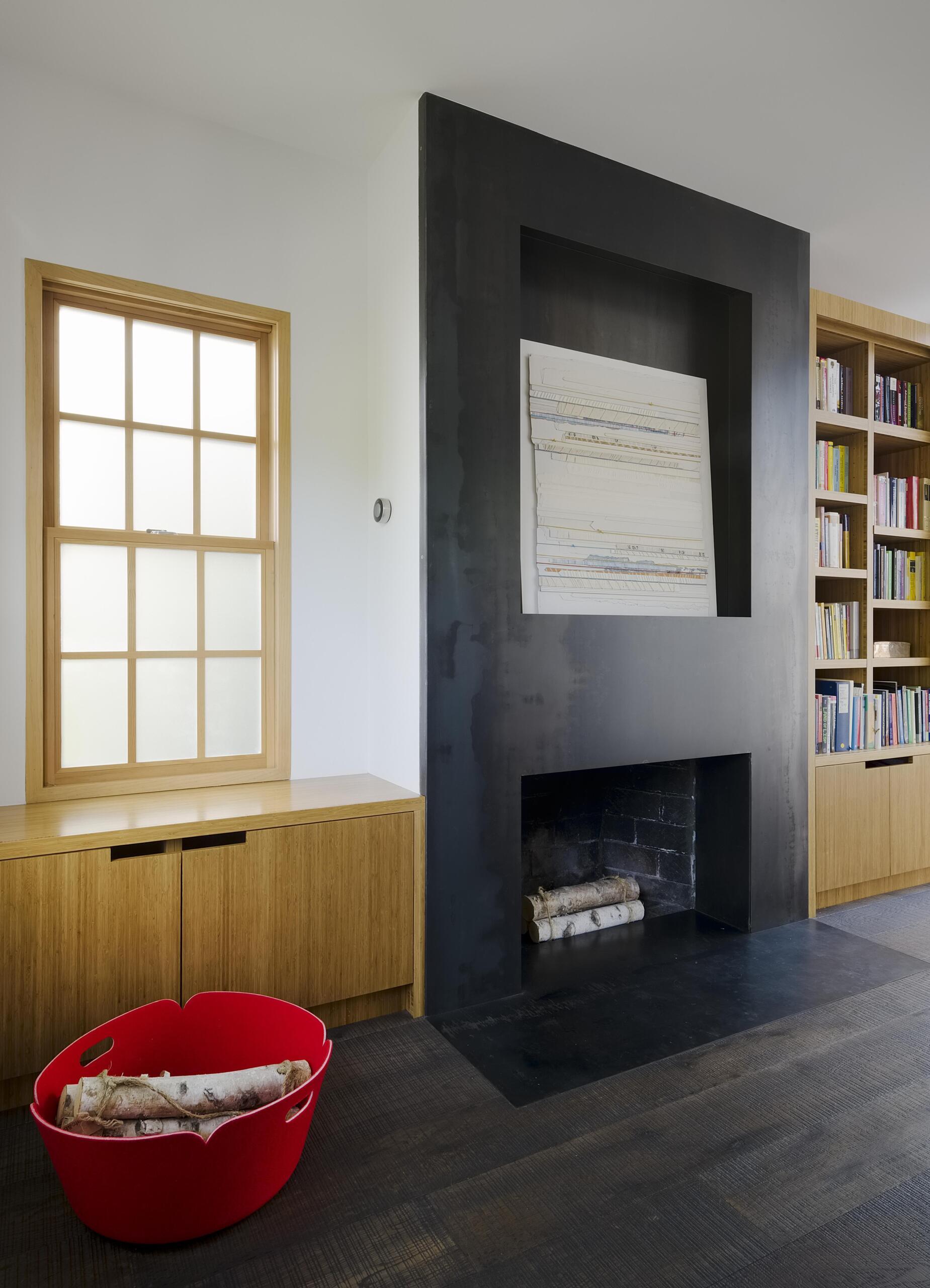 The home office, with built-in shelving and cabinetry, also includes a fireplace. Finished in hot rolled steel with an integrated art niche, it brings a more industrial edge into the space. It’s a mix that feels intentional, pairing clean architectural moves with furniture that adds personality.