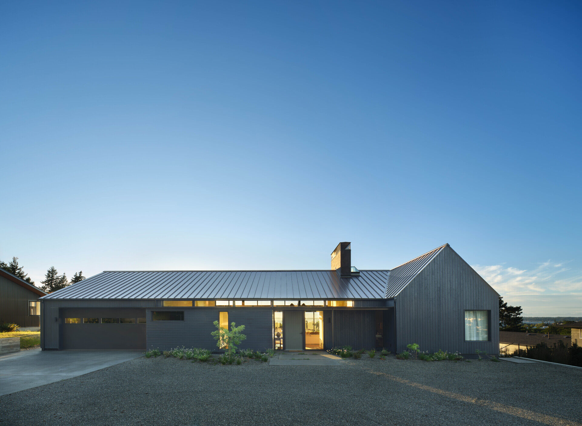 Charred wood siding and a standing seam metal roof create a durable, low-maintenance exterior for this modern home with rich texture.