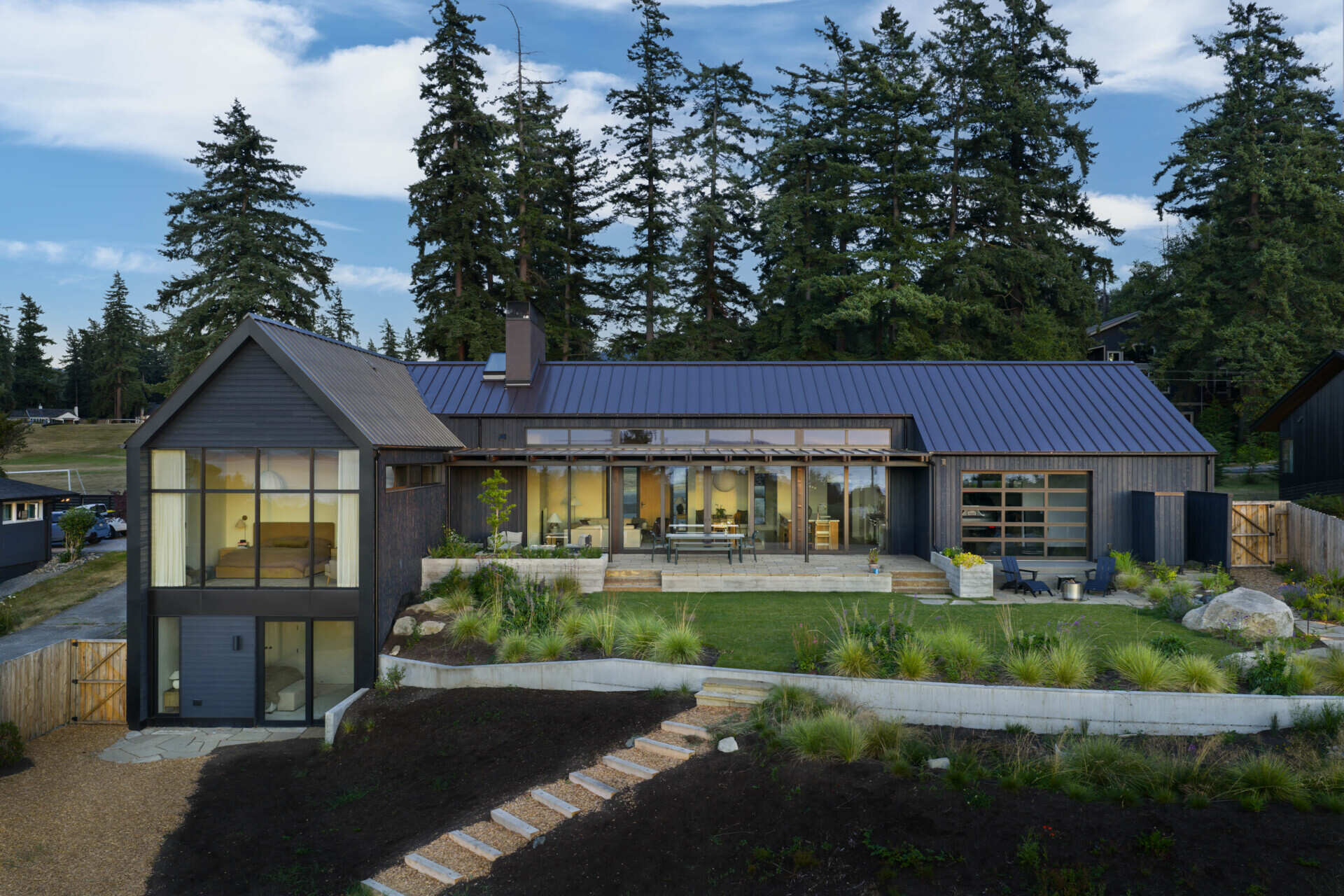 Charred wood siding and a standing seam metal roof create a durable, low-maintenance exterior for this modern home with rich texture.