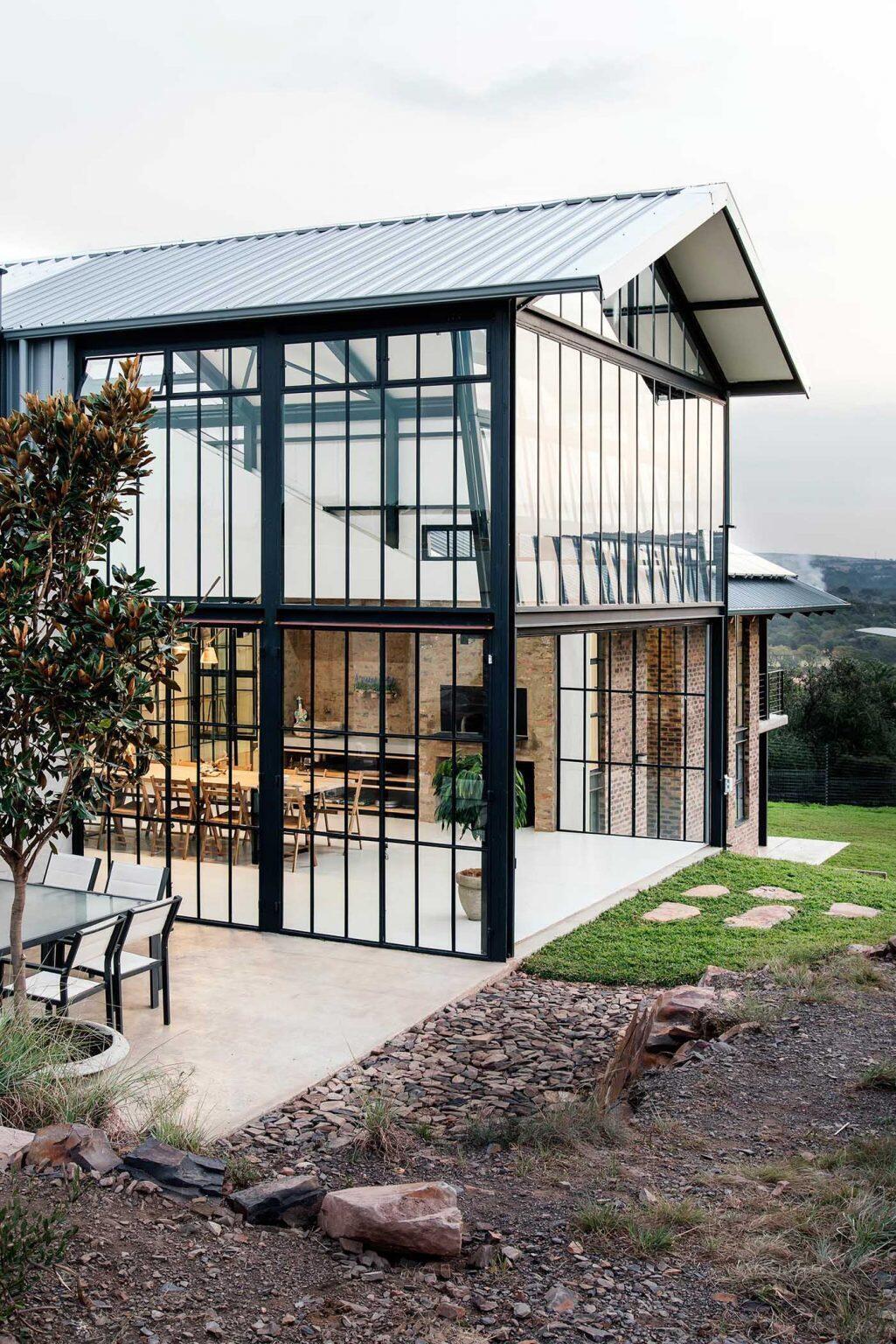 A double-height conservatory with openable walls and a glass floor becomes the heart of this light-filled home.