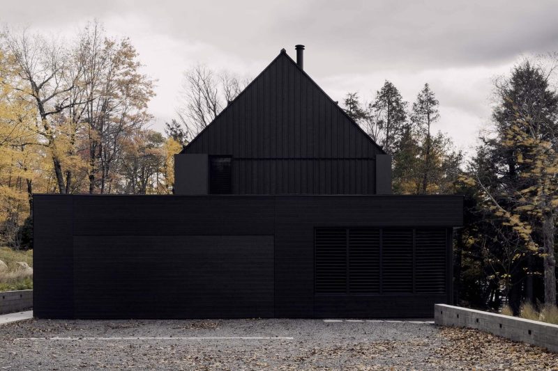 A Linear Black Home Designed Around a Natural Rock Platform