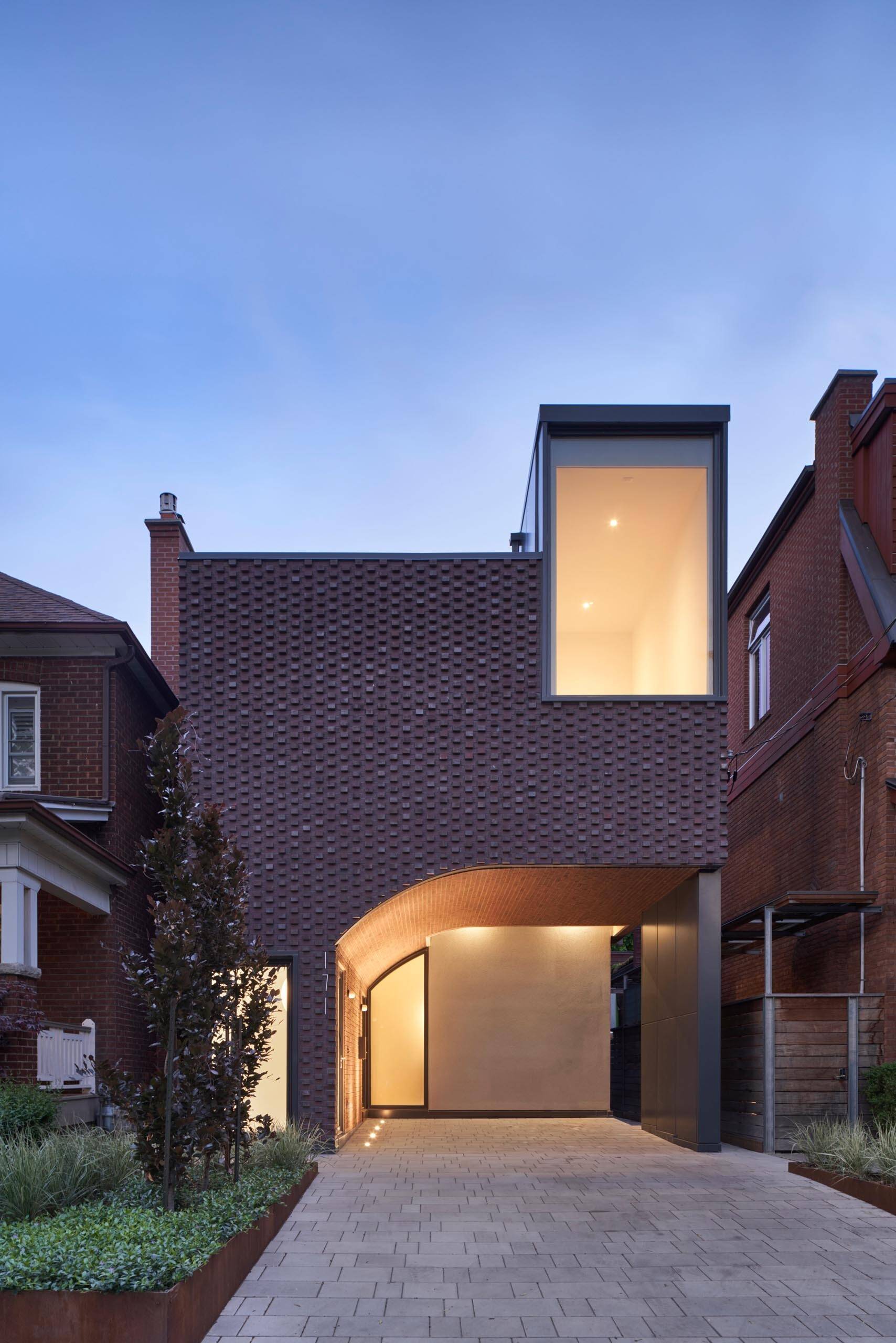 A sculptural brick facade in Toronto uses pattern and depth to create shifting shadows in summer and snow-covered texture in winter.