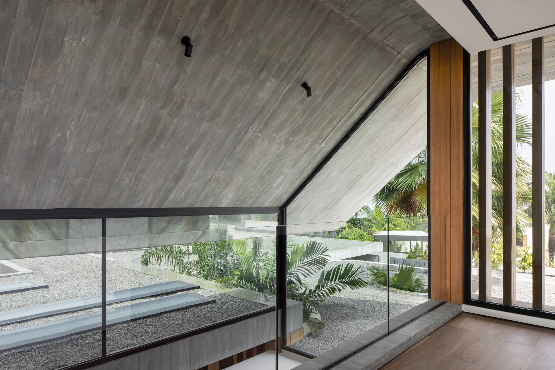 Raw concrete, granite floors, and large openings shape a home filled with natural light and layered textures.