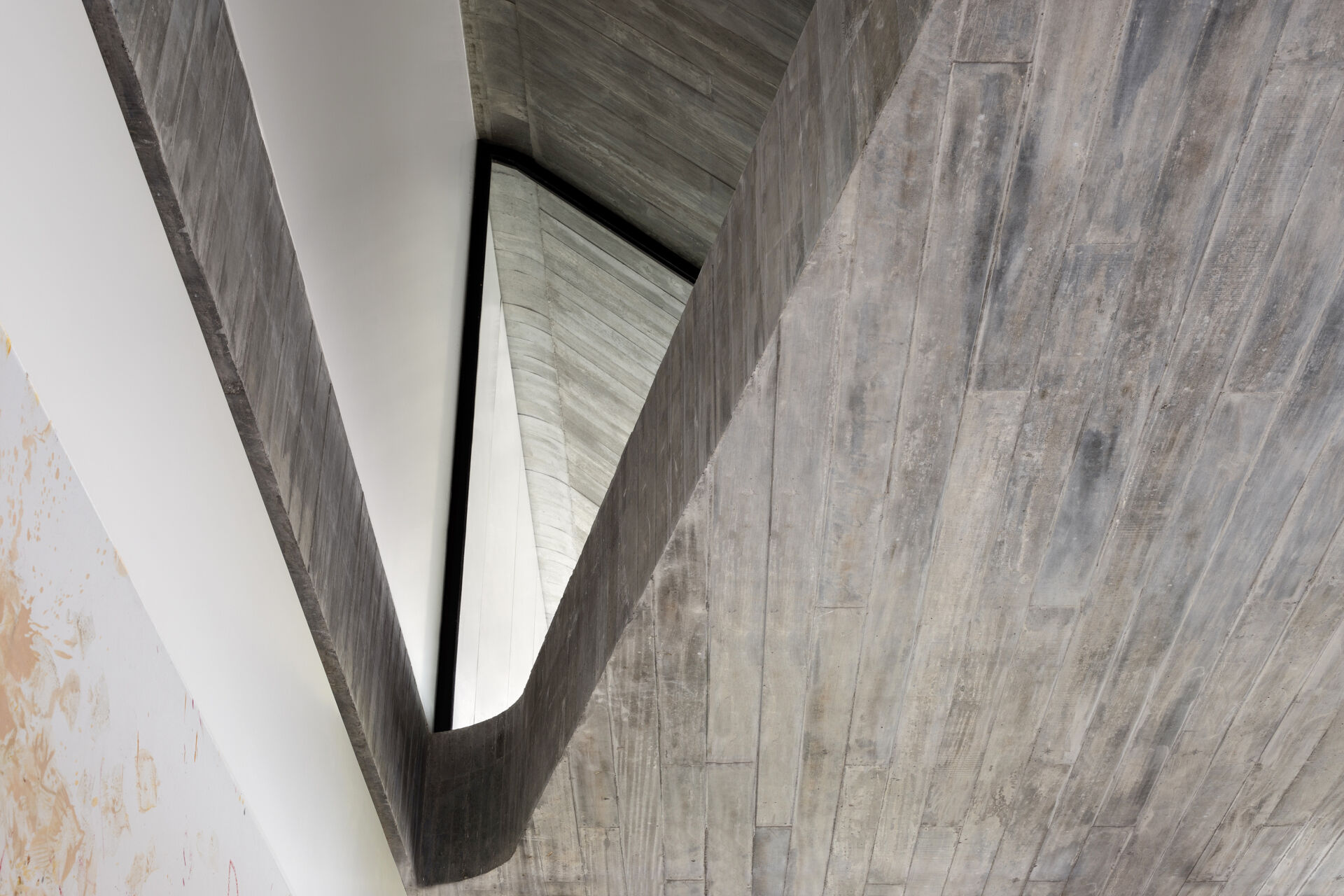 Raw concrete, granite floors, and large openings shape a home filled with natural light and layered textures.