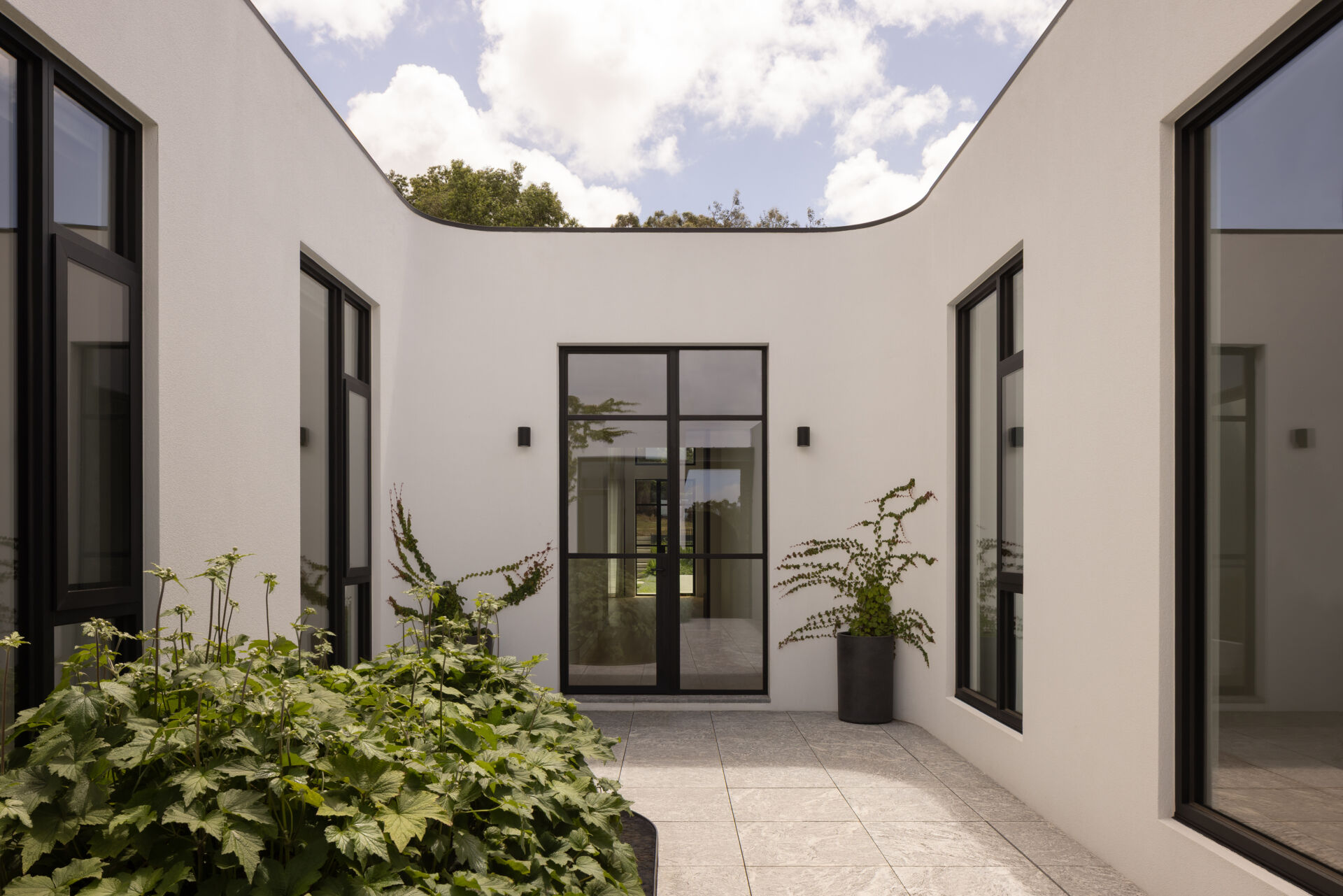 A central courtyard with a reflective pond and garden creates a striking entry sequence and anchors the entire layout.