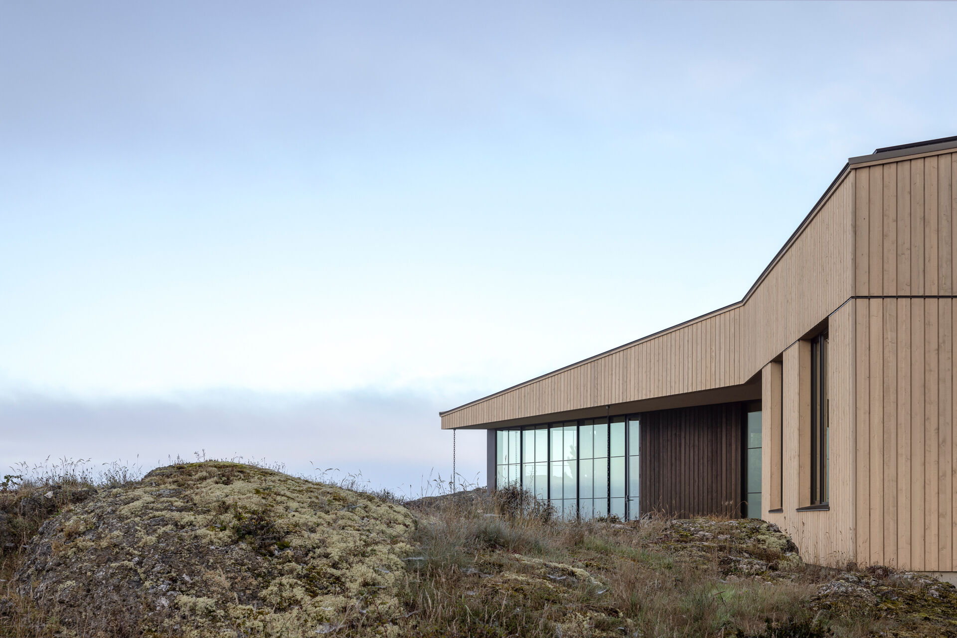 Cedar cladding and weathered finishes allow this home to blend into the rugged coastline.