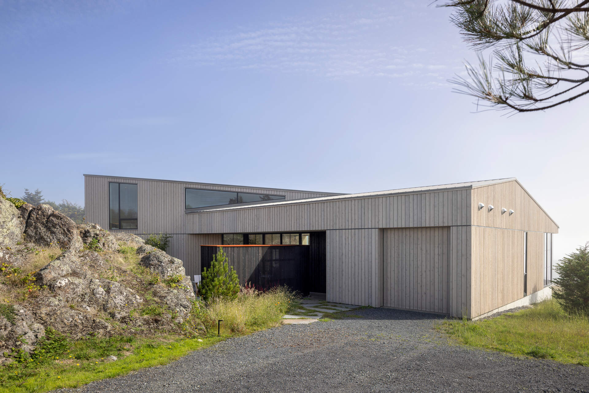 Cedar cladding and weathered finishes allow this home to blend into the rugged coastline.