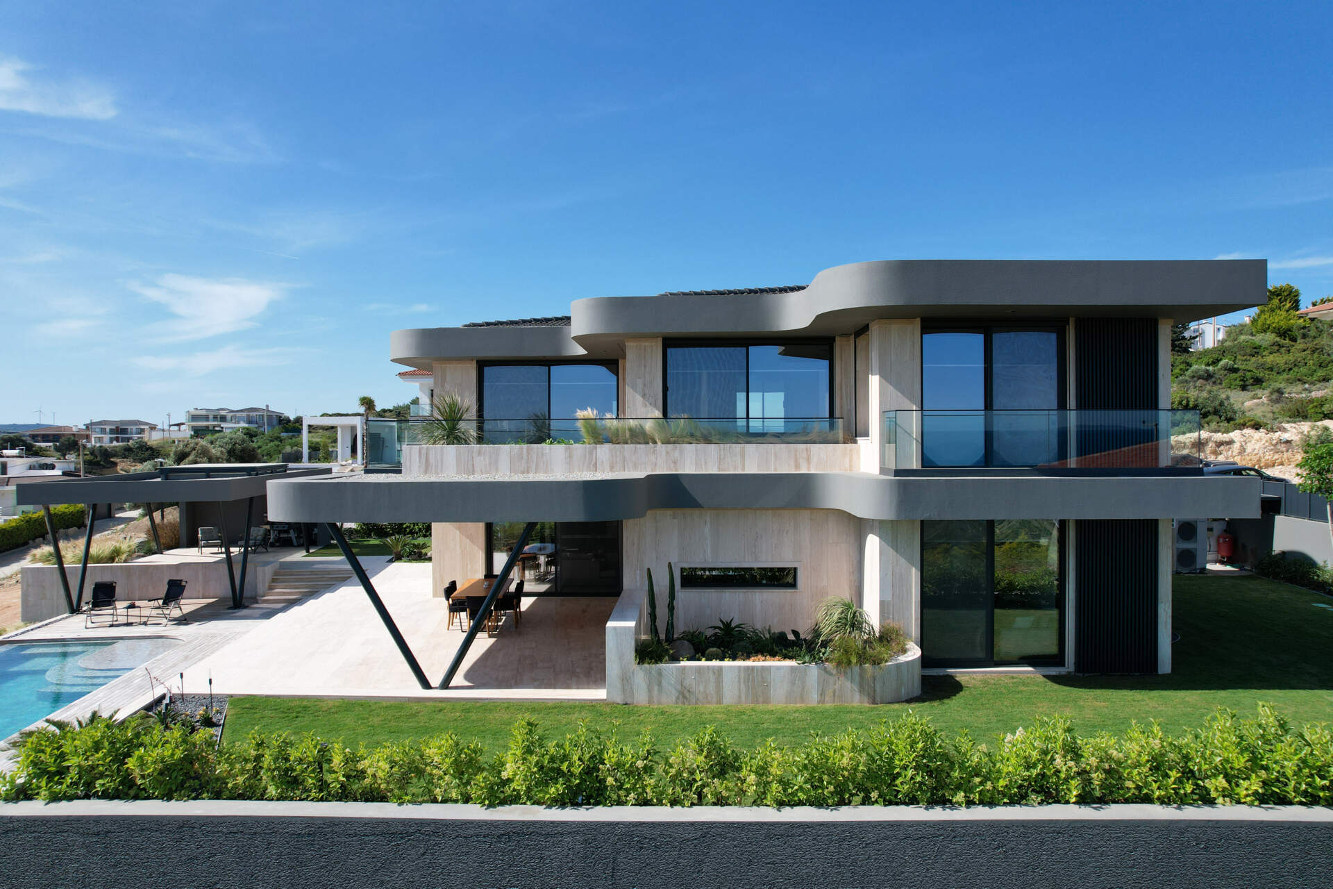 A modern home has wave-inspired architecture with sculptural eaves that create shaded outdoor spaces throughout the day.