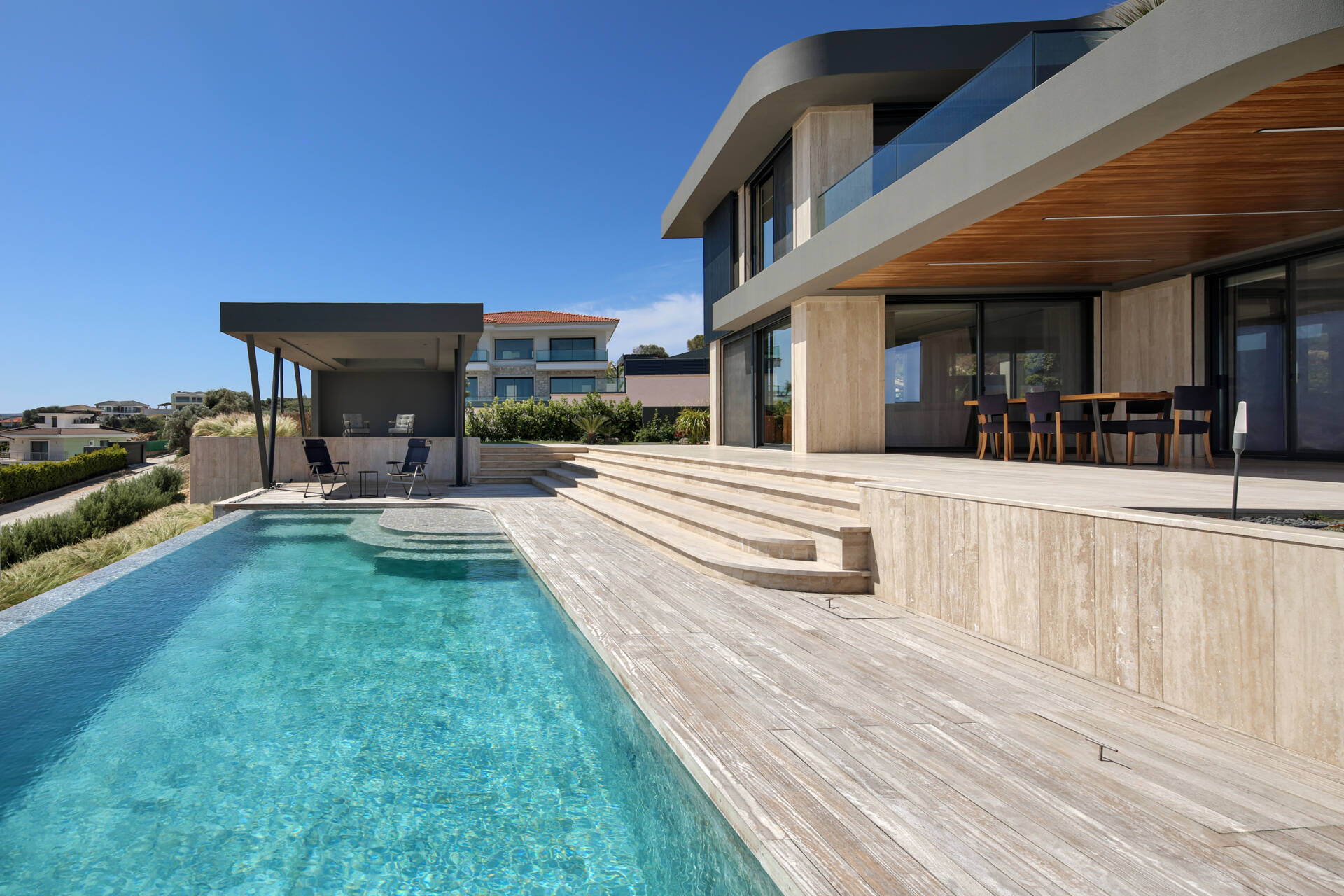 A seamless indoor-outdoor layout where living spaces open directly to the pool, garden, and expansive coastal views.