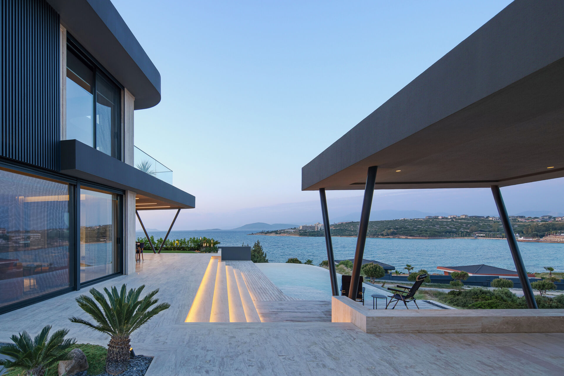 A seamless indoor-outdoor layout where living spaces open directly to the pool, garden, and expansive coastal views.