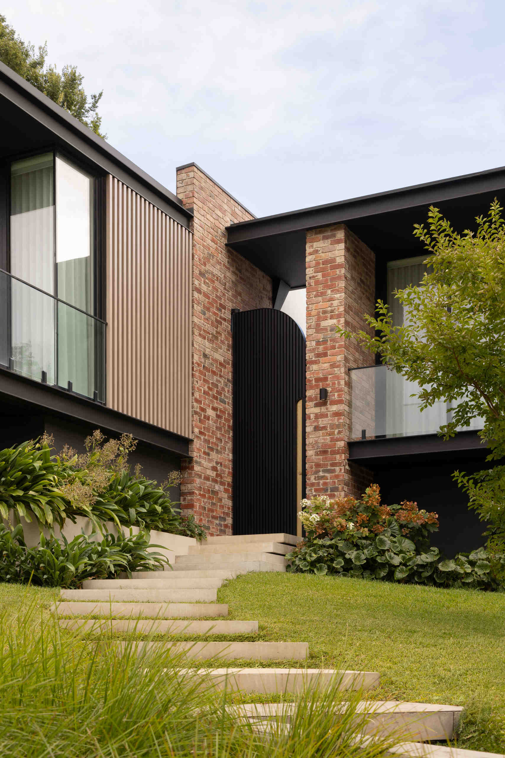 The journey begins with steps that lead to a large metal courtyard door. Passing through it introduces a slower pace, where movement becomes intentional and the transition into the home feels defined and memorable. The use of reclaimed clinker bricks ties the home back to its past, while also grounding it within the established character of the area.