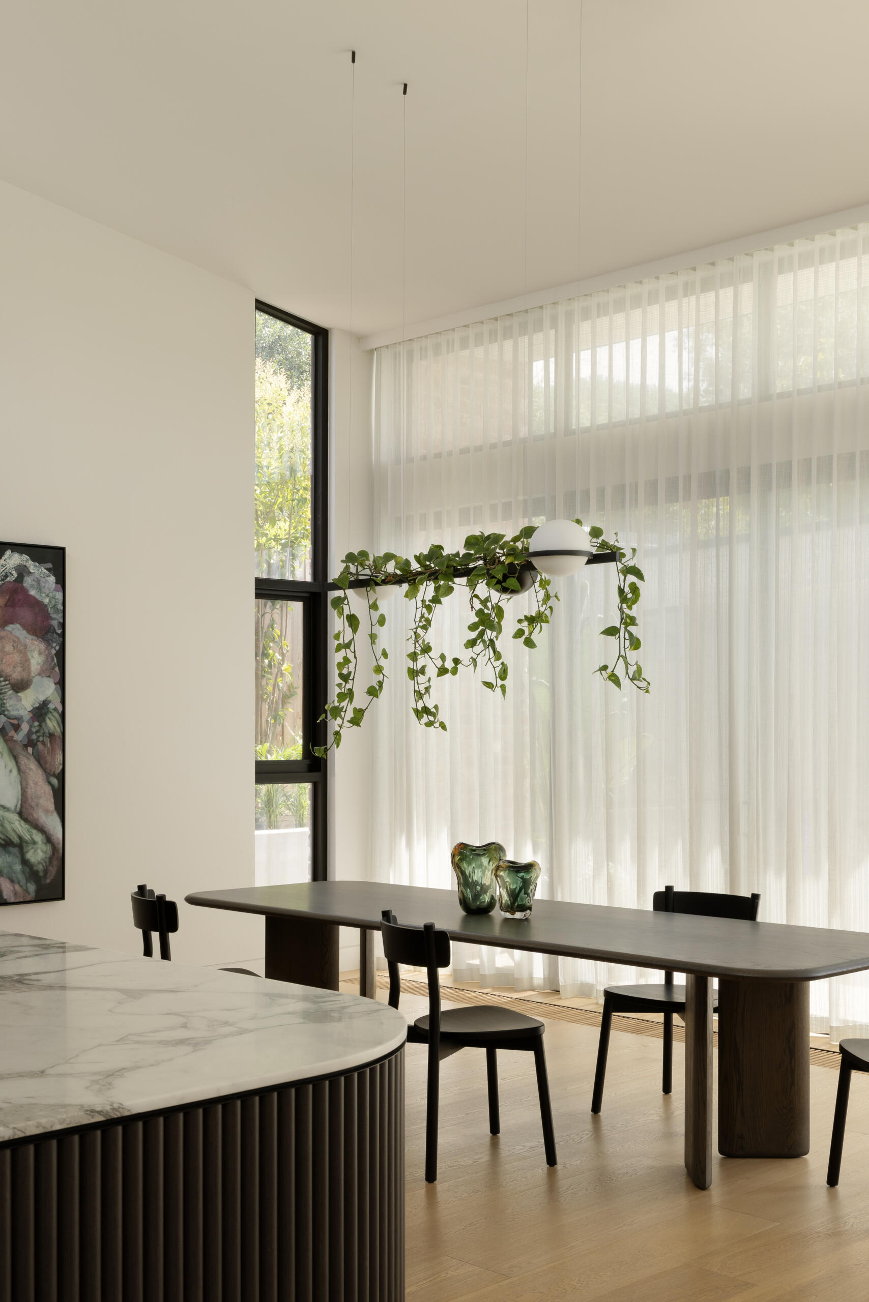 The dining space sits naturally between the kitchen and living zones, forming part of a continuous open-plan layout. It supports large gatherings without feeling oversized, maintaining a sense of intimacy while still being part of the broader entertaining space.