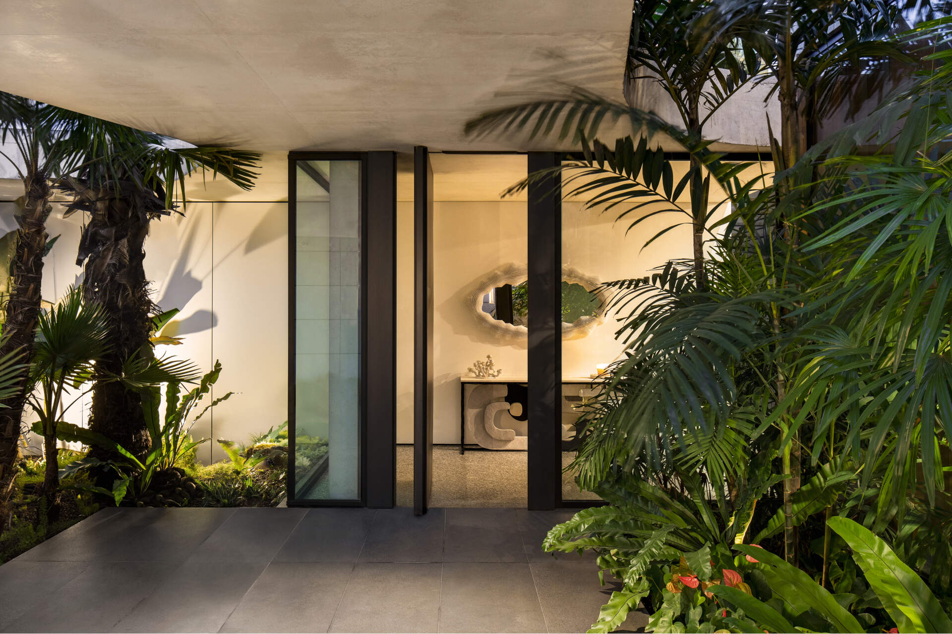 A striking concrete canopy leads into a landscaped forecourt, creating a calm and open arrival sequence.