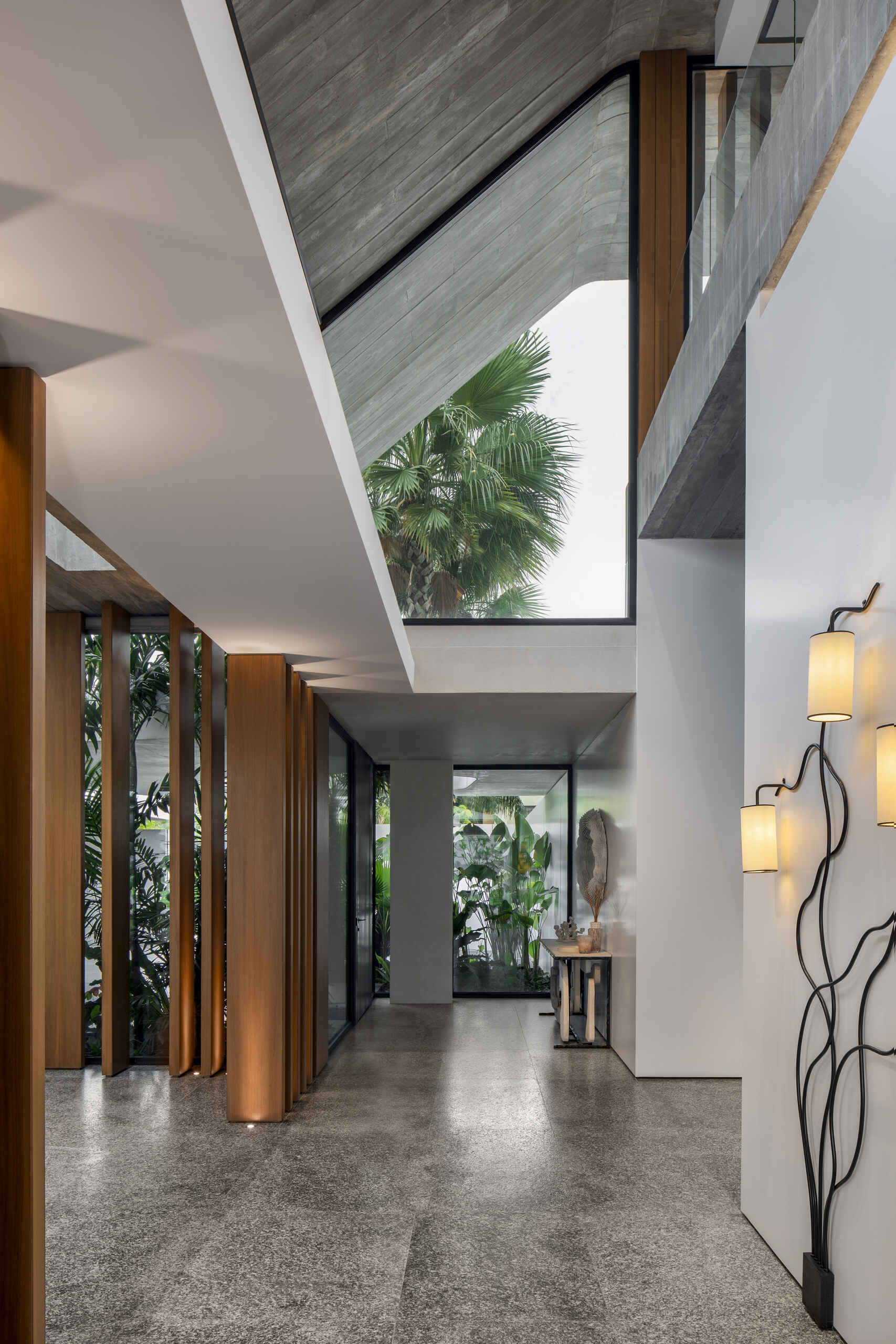 Raw concrete, granite floors, and large openings shape a home filled with natural light and layered textures.