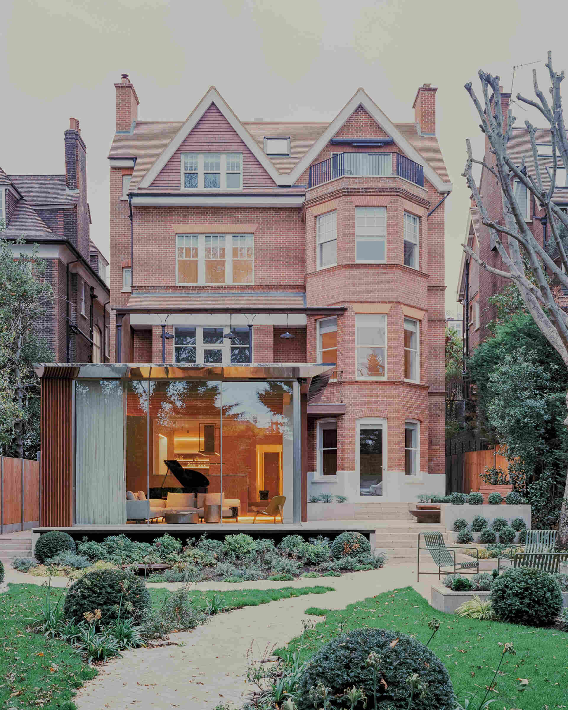 This cascading extension wrapped in iroko timber and topped with a reflective roof blends structure and greenery in a striking way.