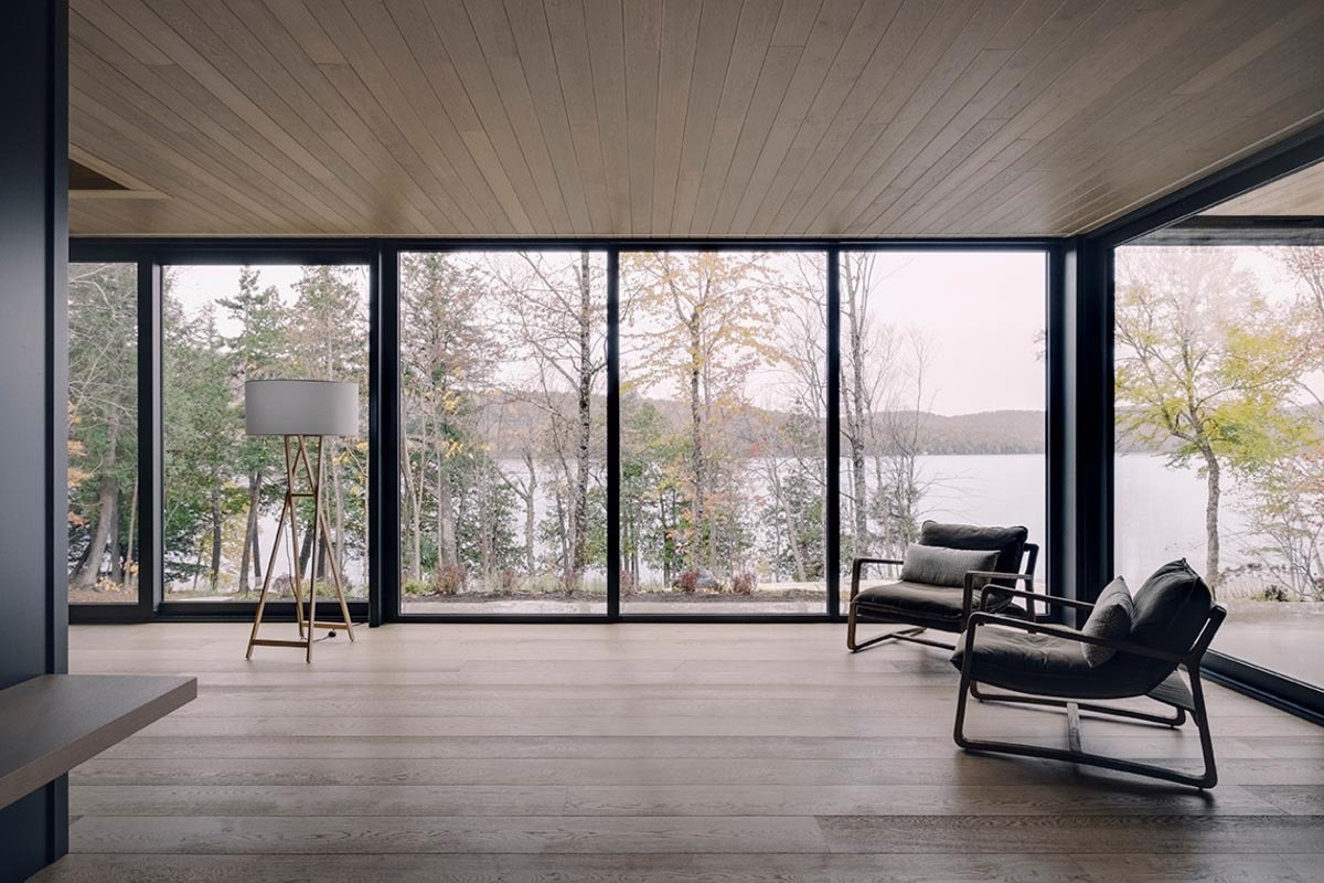 A cozy living room combines wood ceilings, a black fireplace, and a stone wall to create a rich mix of textures in a modern setting.