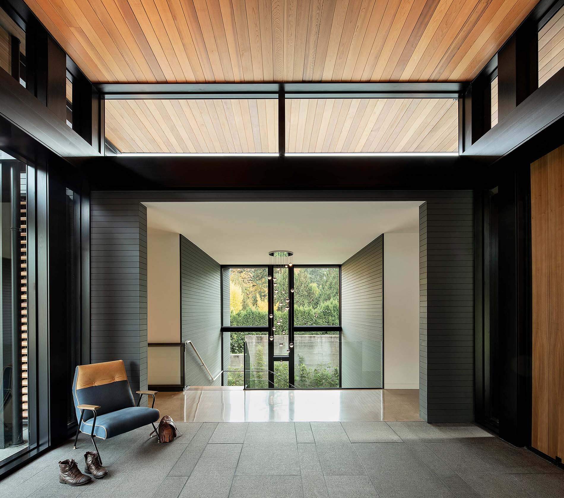 Wood, steel, stone, and glass come together in this modern hillside home, creating a clean and natural look that blends with the surrounding forest.