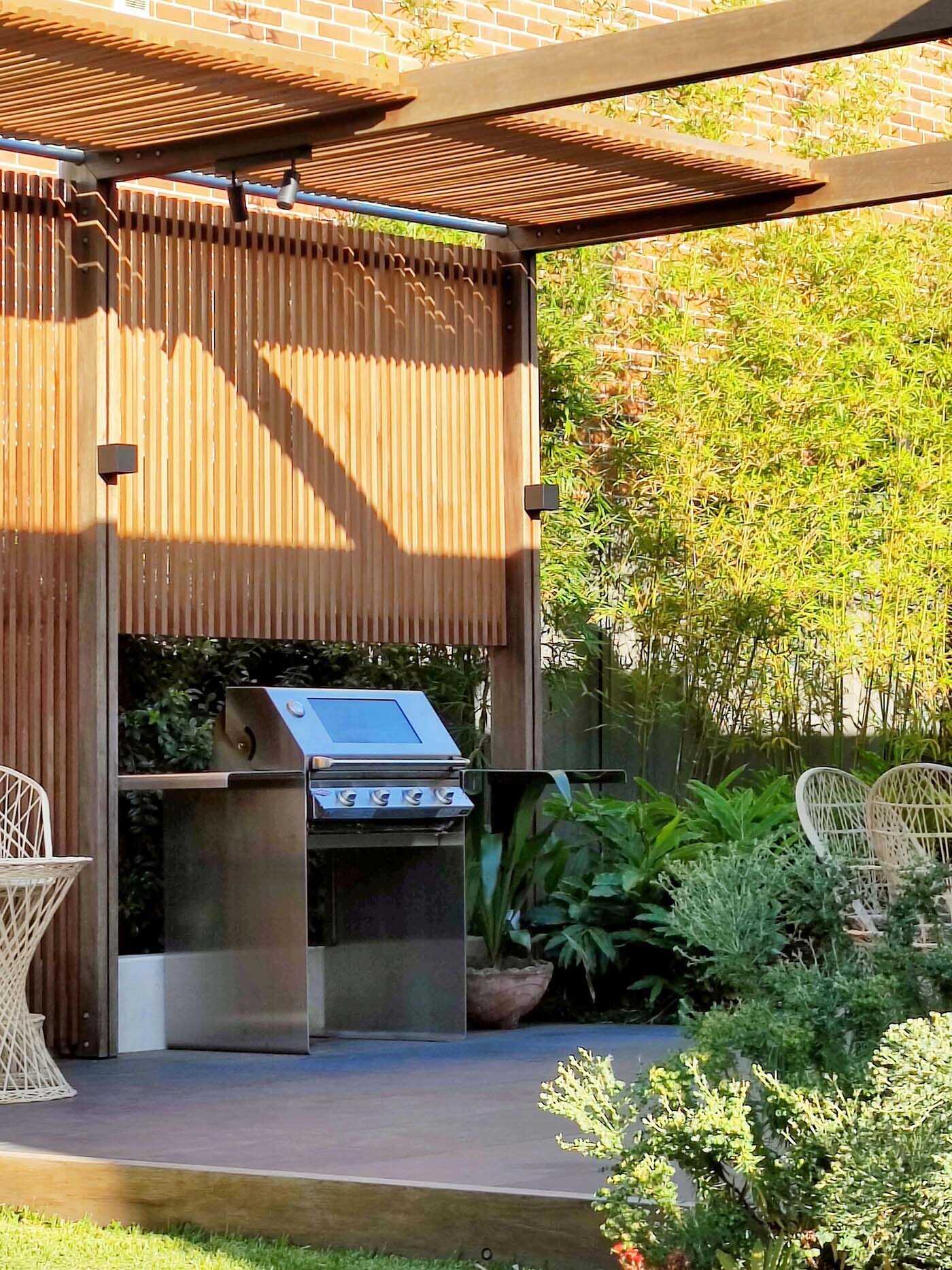 La terraza cubierta al aire libre cuenta con una zona de barbacoa y comedor, diseñada para una perfecta vida interior y exterior en una casa contemporánea de Sydney.