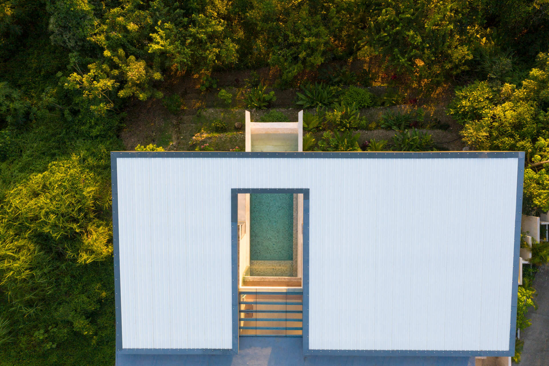 A modern hillside home in Santa Teresa, Costa Rica that hides its full size from the street before opening up to expansive ocean views.