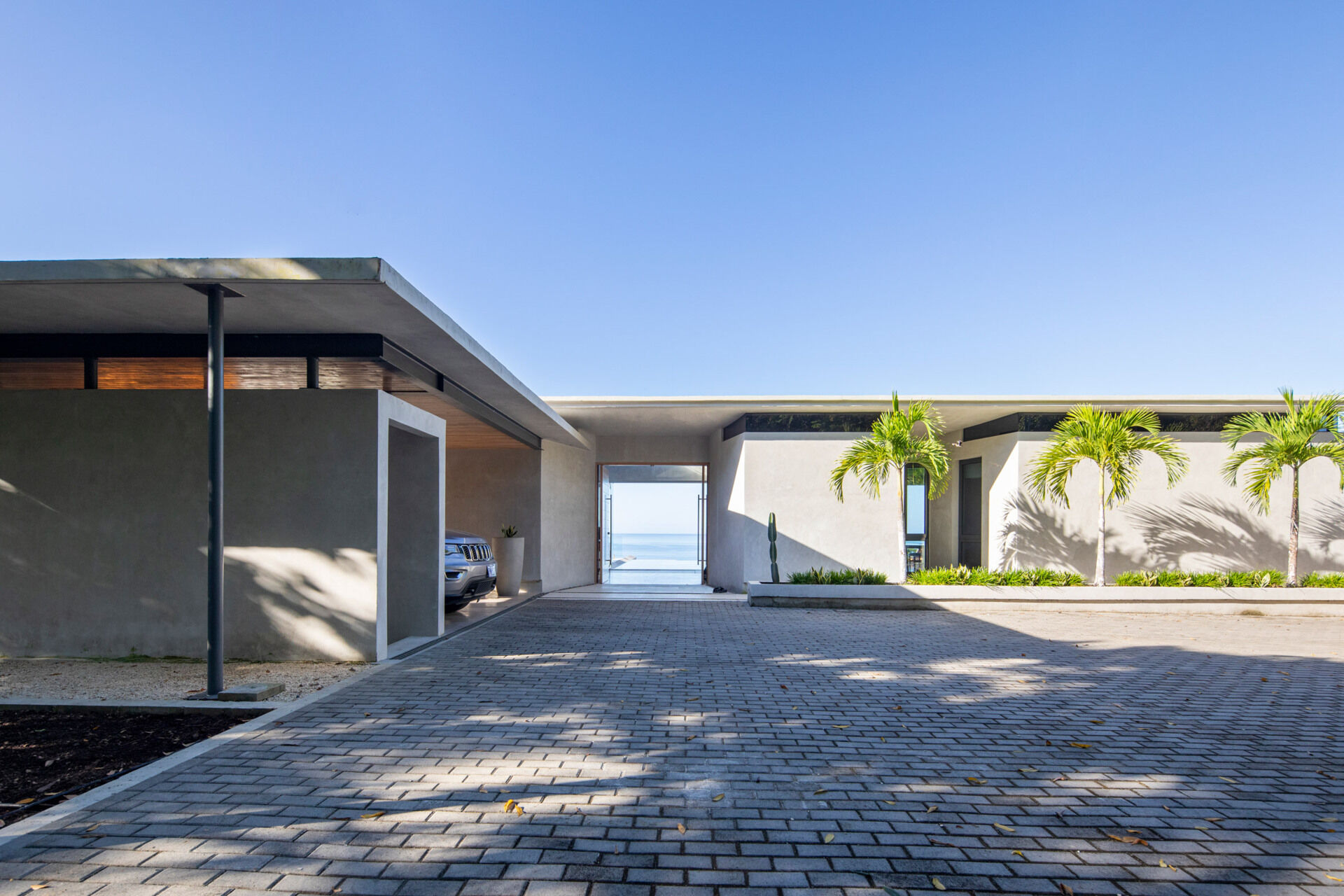 A sweeping wood-lined roof that protects the home, frames the pool, and helps keep the interior cool in a tropical climate.