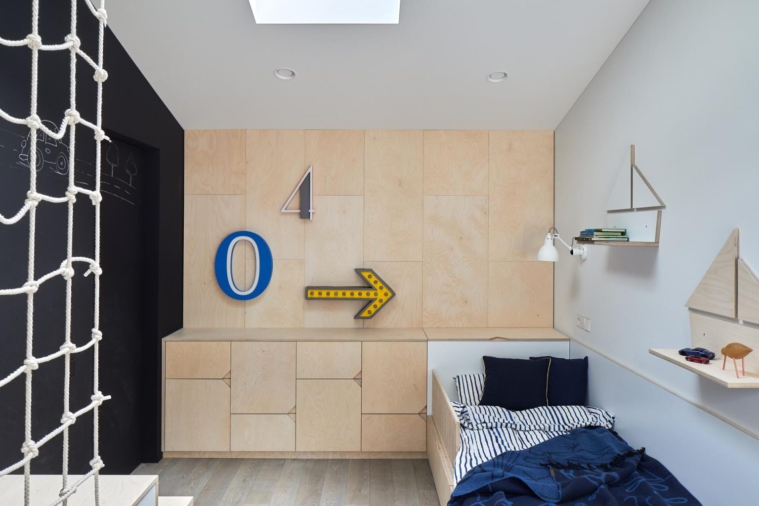 This bedroom features a chalkboard wall alongside built-in stepped storage and a net detail, adding a sense of play.
