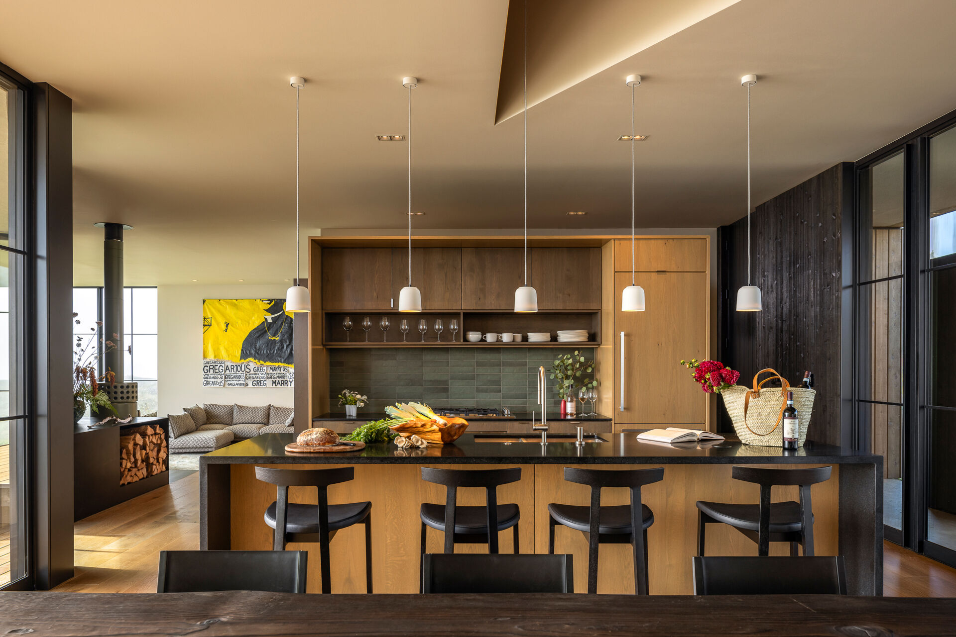 An 11-foot dining table anchors this open-plan space designed for gathering and connection. The kitchen flows naturally from this space, keeping everything connected and open.