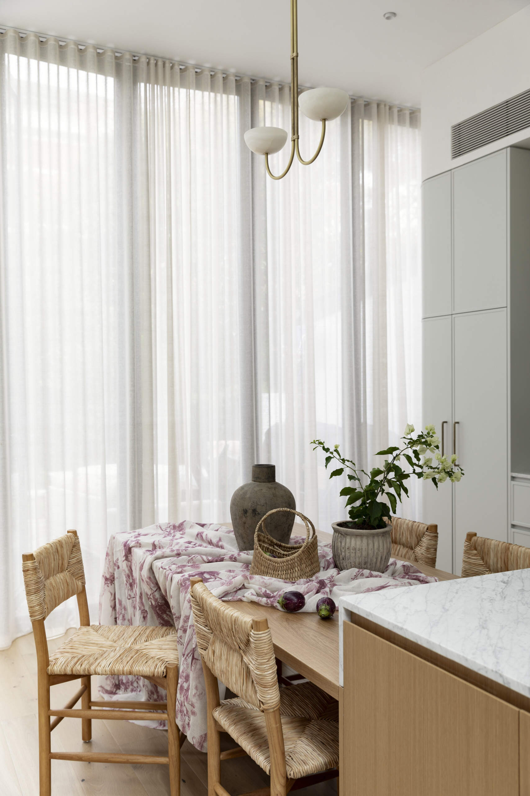 At the center of the open-plan layout, the kitchen island doubles as a dining table. It works as both a gathering point and a functional surface, linking the kitchen and living areas.