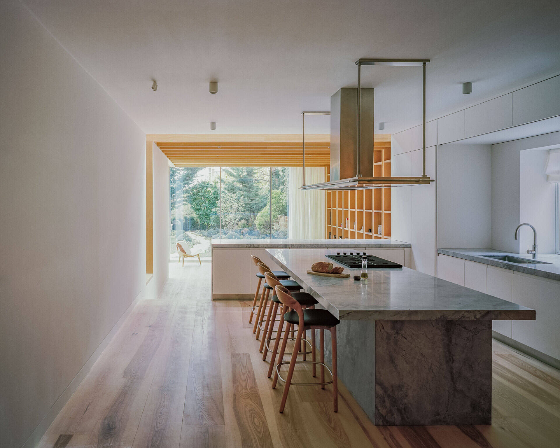 Quartzite surfaces and a central island anchor this open kitchen, designed to stay connected to both the living area and the view.