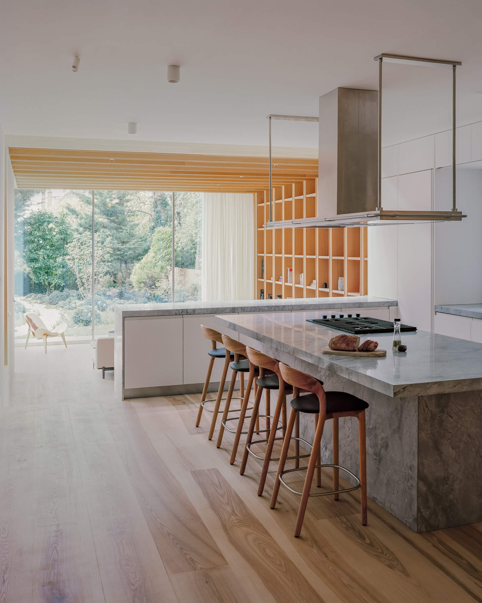 Quartzite surfaces and a central island anchor this open kitchen, designed to stay connected to both the living area and the view.