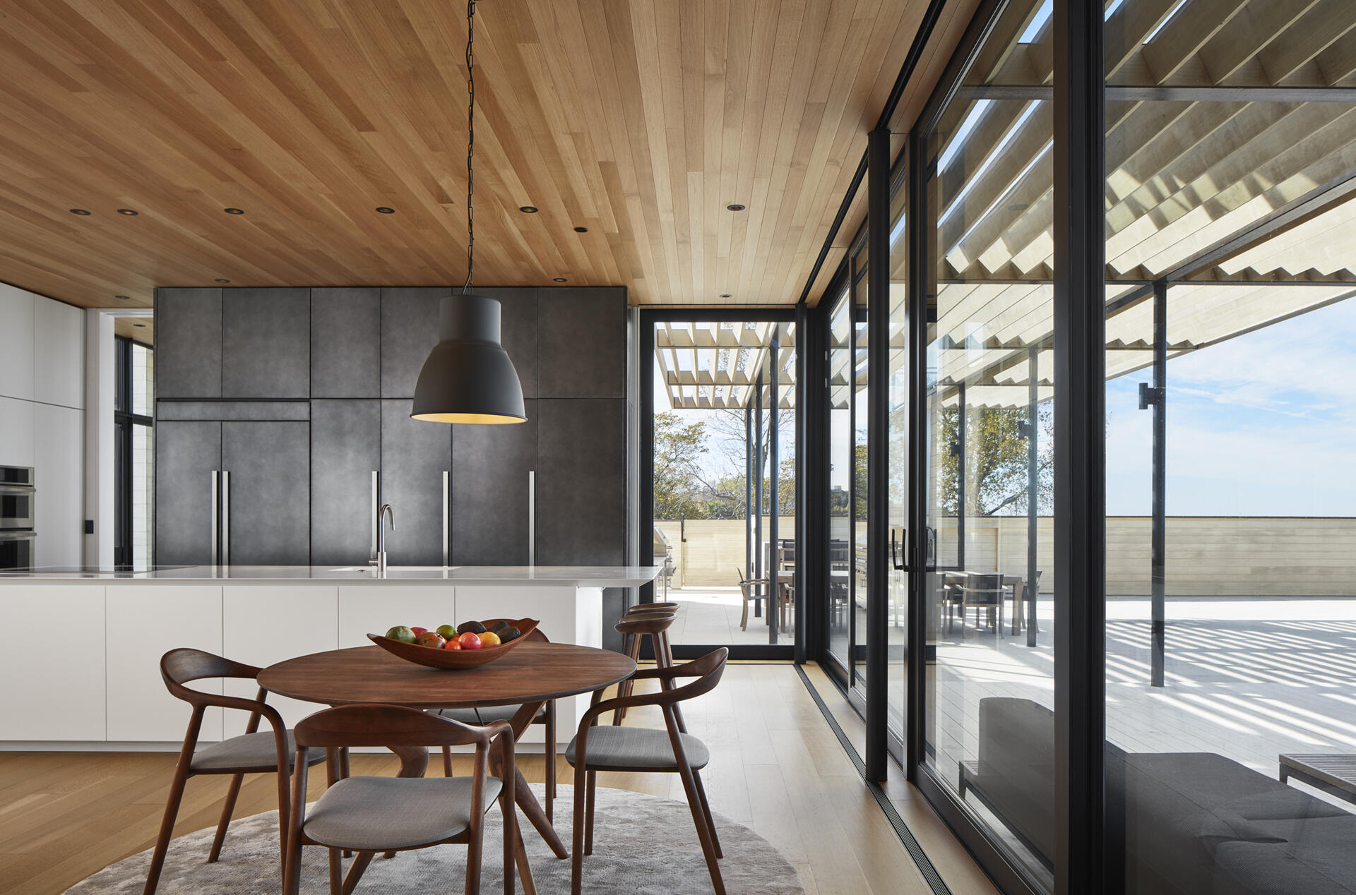 Warm wood ceilings and white oak floors bring softness to this minimalist interior design.