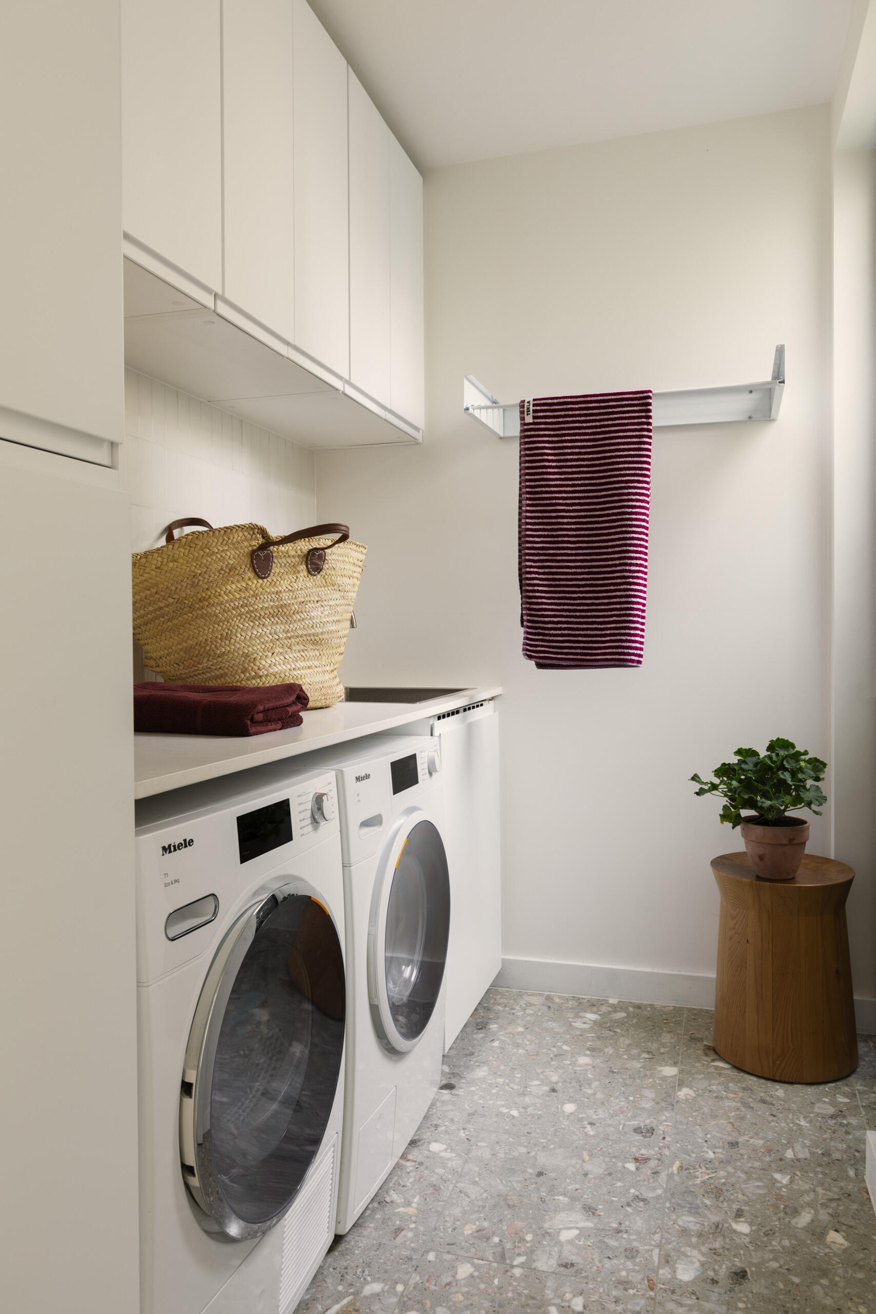 This laundry room shows how hardworking spaces can still feel calm. Crisp white cabinetry keeps the look clean, while the terrazzo floor brings in soft pattern and durability that can handle everyday messes with ease.