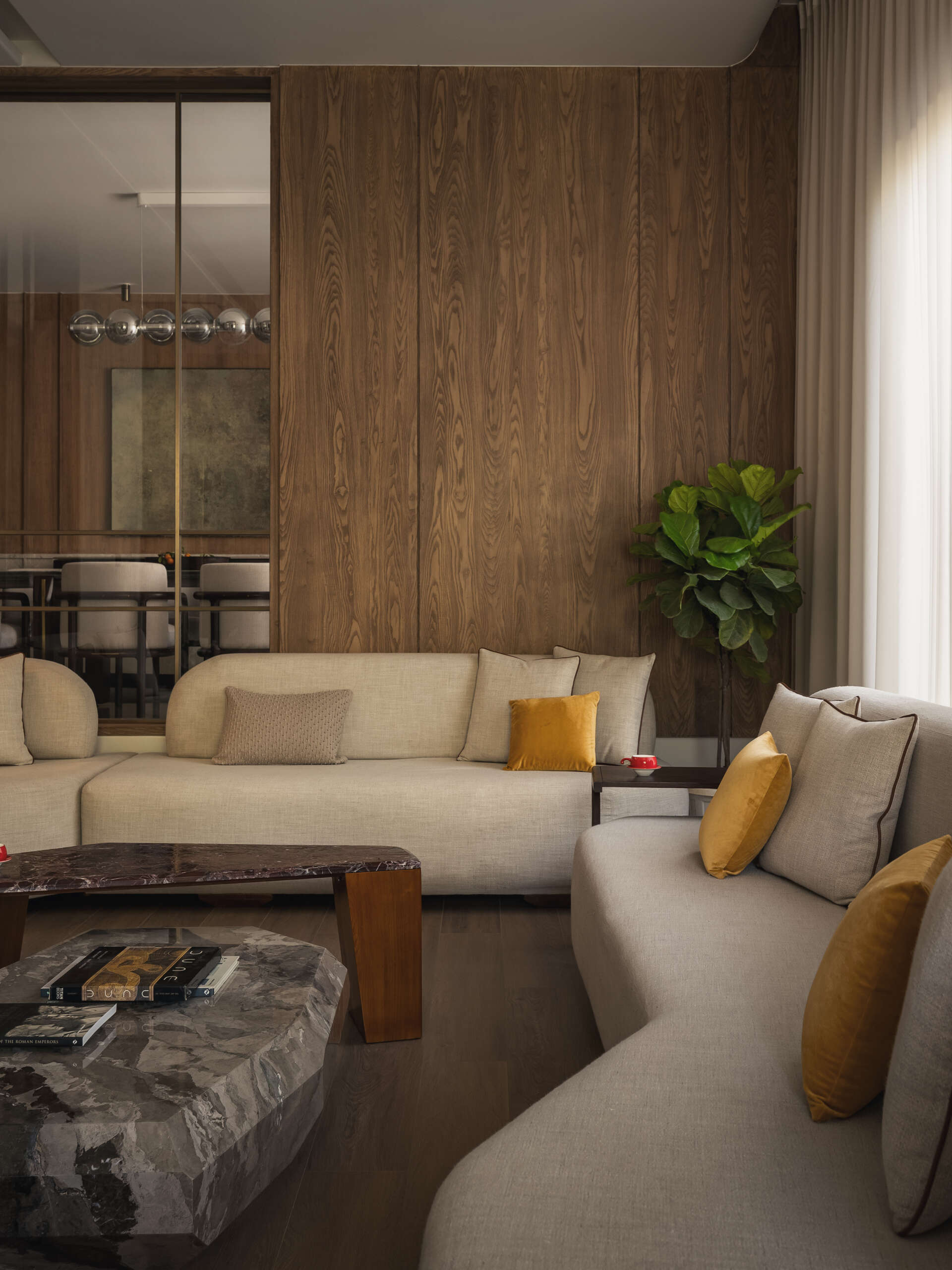 The living room continues the idea of softness and balance. Muted tones form the base, allowing the materials to stand out without overwhelming the space.