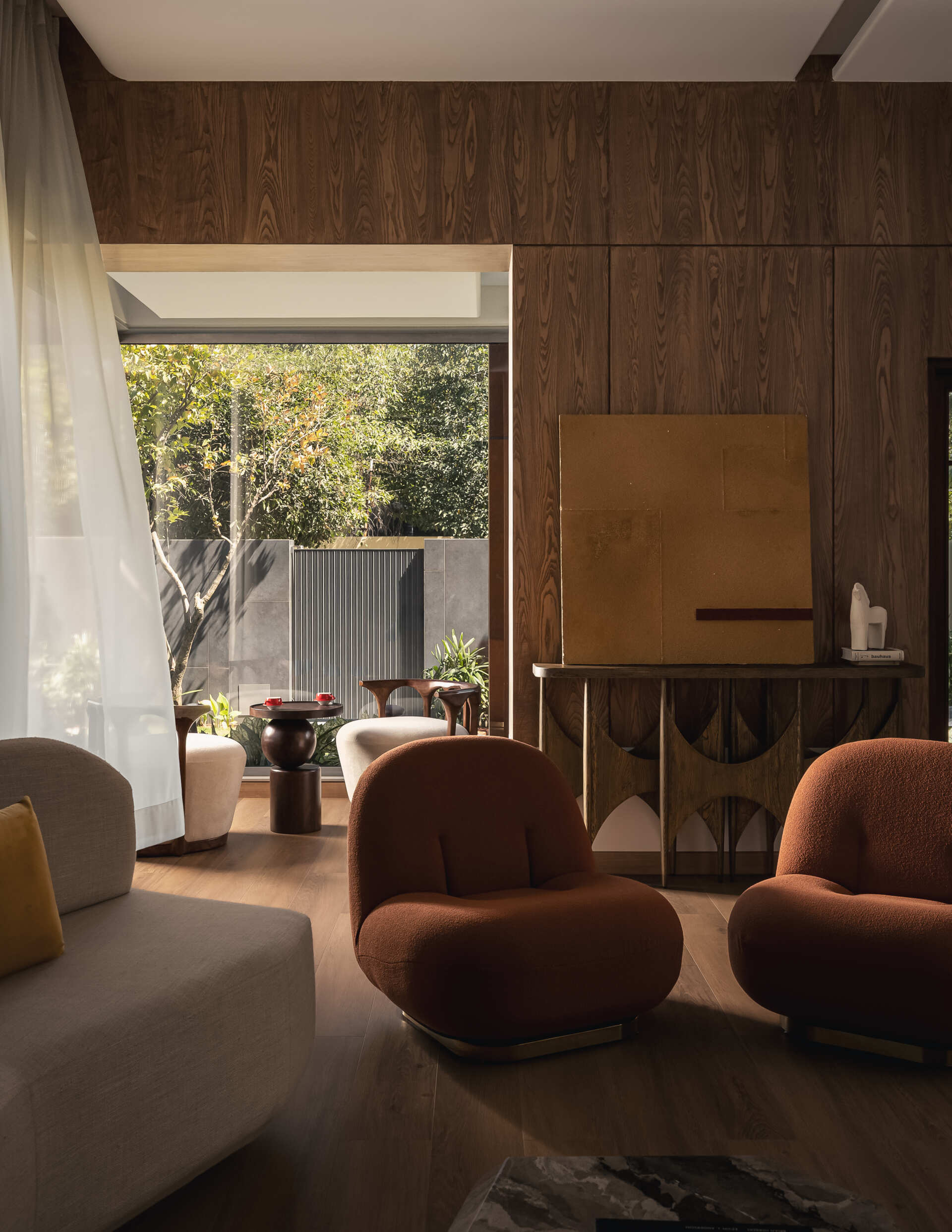 The living room continues the idea of softness and balance. Muted tones form the base, allowing the materials to stand out without overwhelming the space.