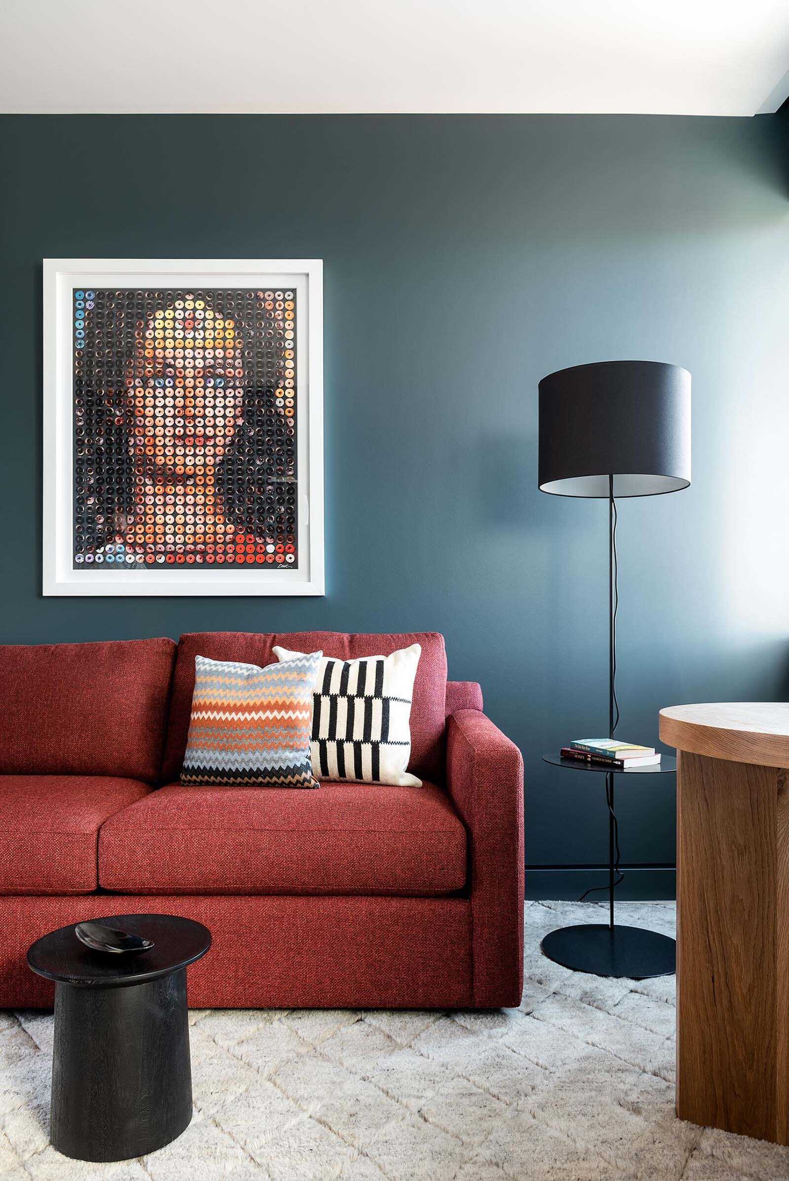 Secondary living room with a bold blue-gray accent wall creating a relaxed and cozy space.