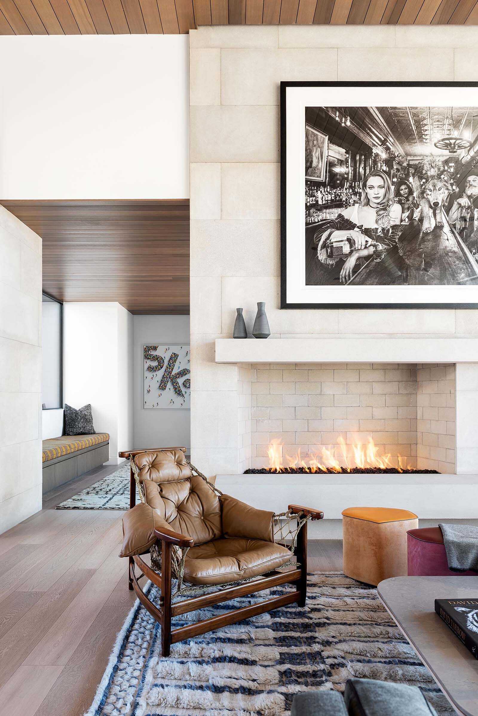 Living room with large windows, sliding glass doors, and a fireplace creating a warm focal point with mountain views.