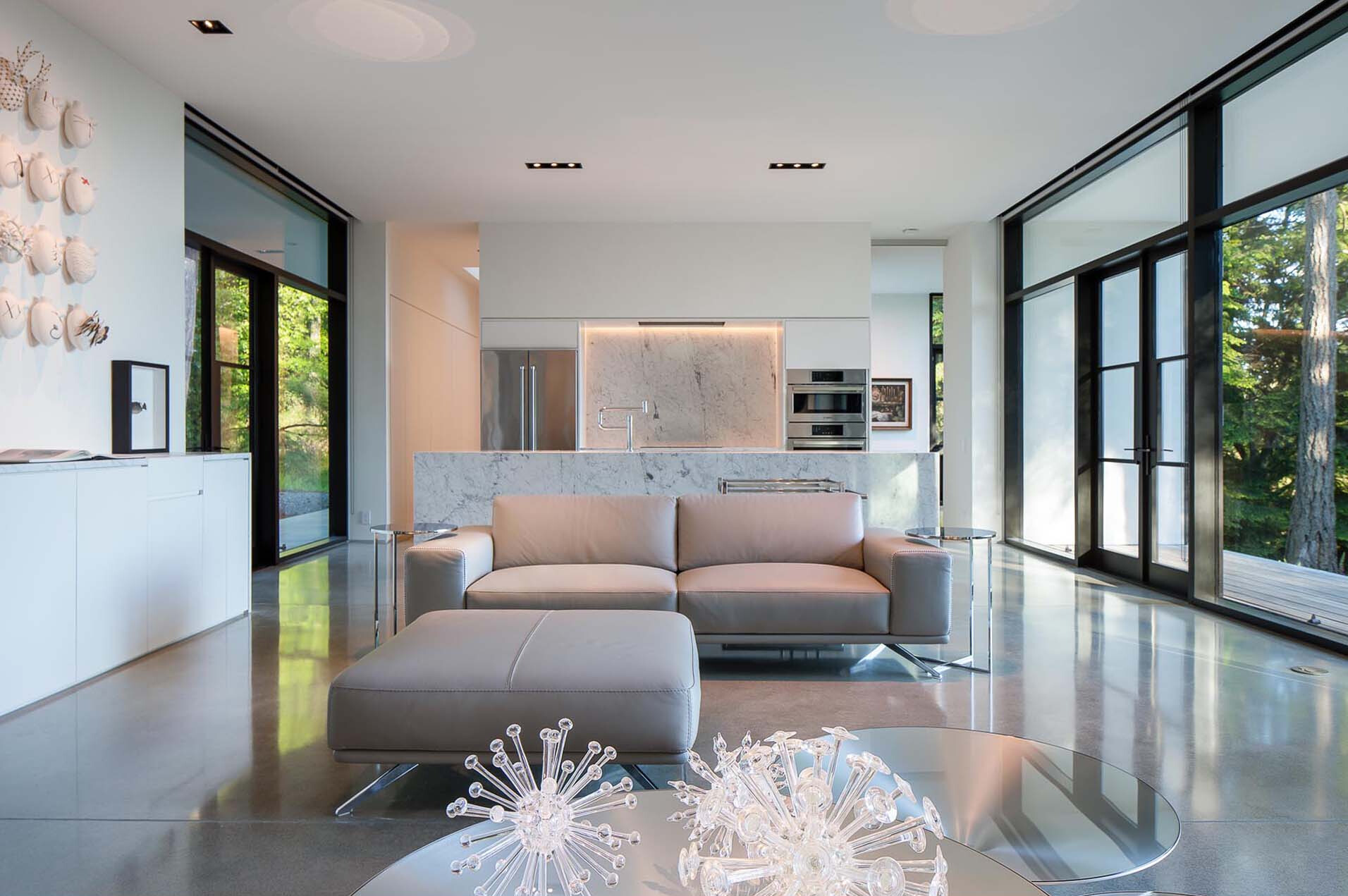 White surfaces, marble, and concrete create a gallery-like interior designed to highlight art and objects.