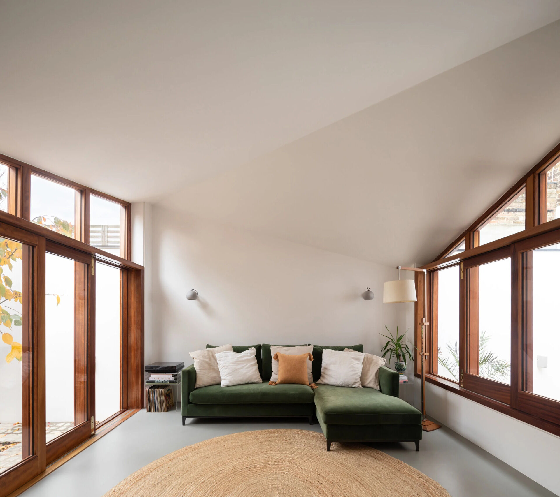 A small courtyard with a tree sits between rooms, framed by sliding glass doors for a calm indoor-outdoor connection.