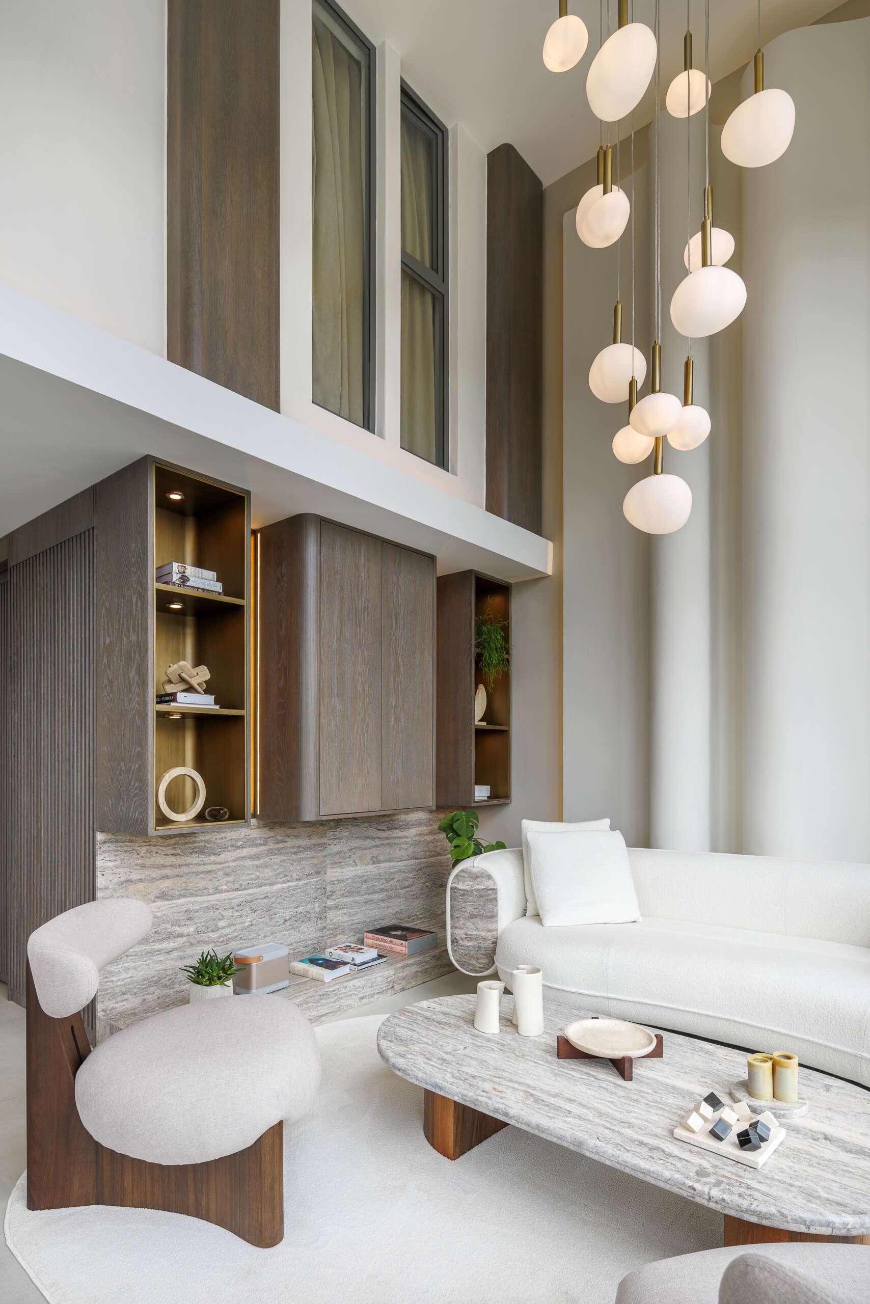 A balanced living room where contrast becomes harmony, blending softness, sculpture, structure, light, and natural materials into one cohesive space.
