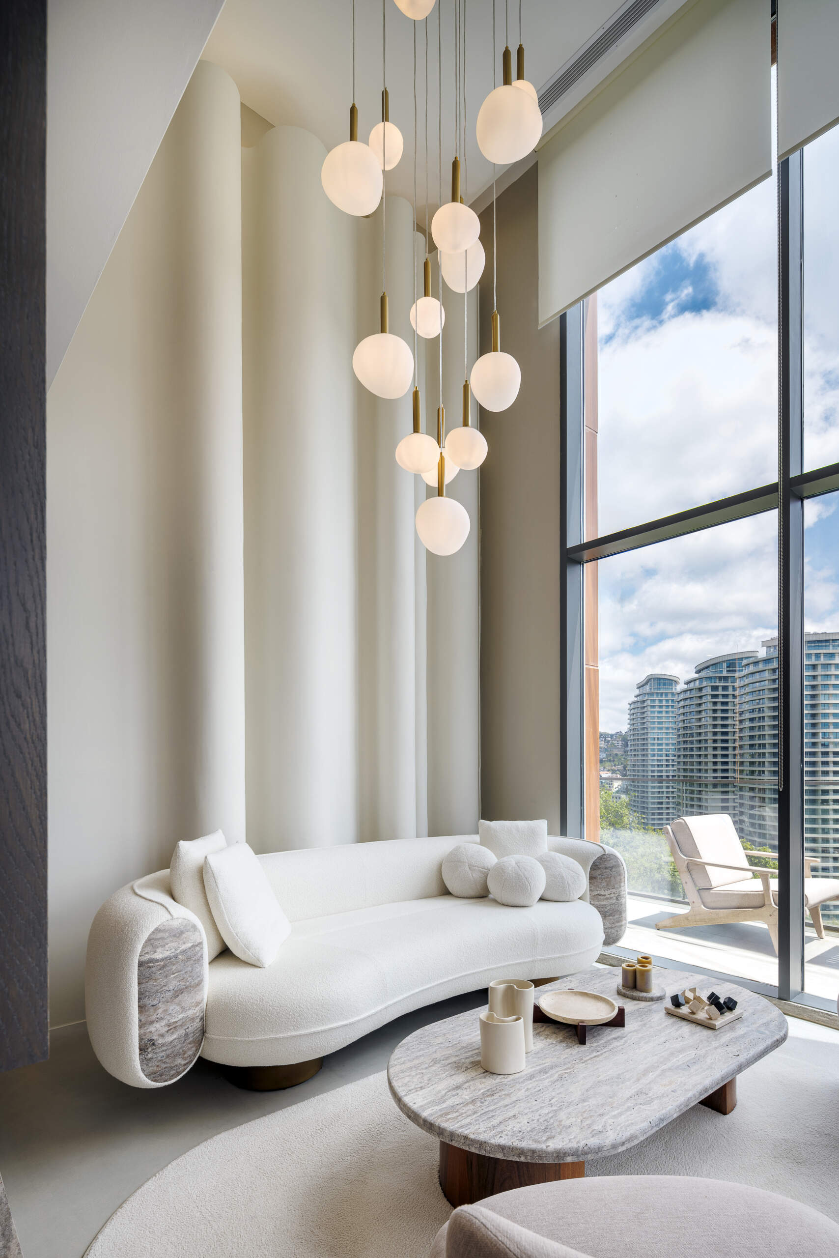 A balanced living room where contrast becomes harmony, blending softness, sculpture, structure, light, and natural materials into one cohesive space.