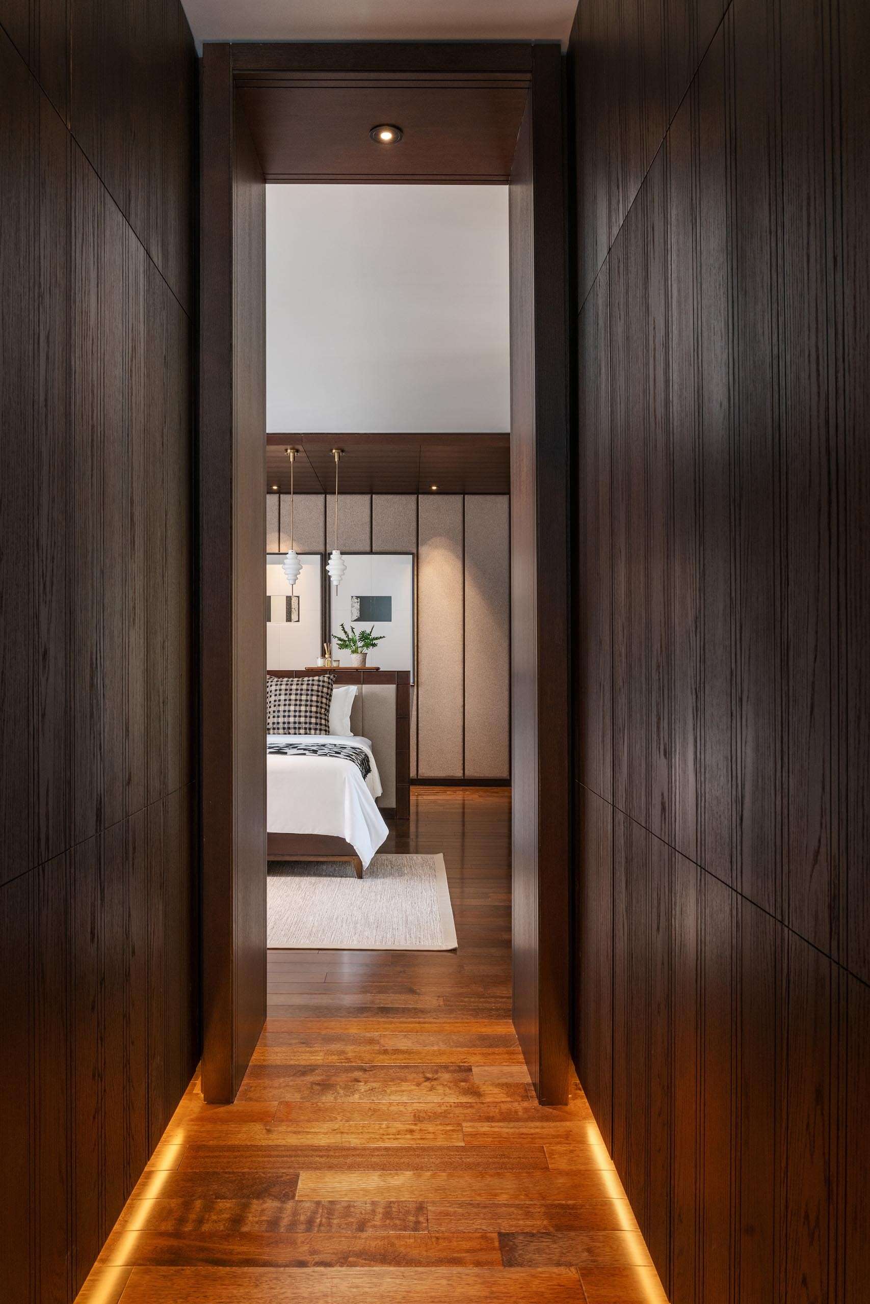 A dark wood hallway with built-in storage and soft lighting that adds warmth and depth.