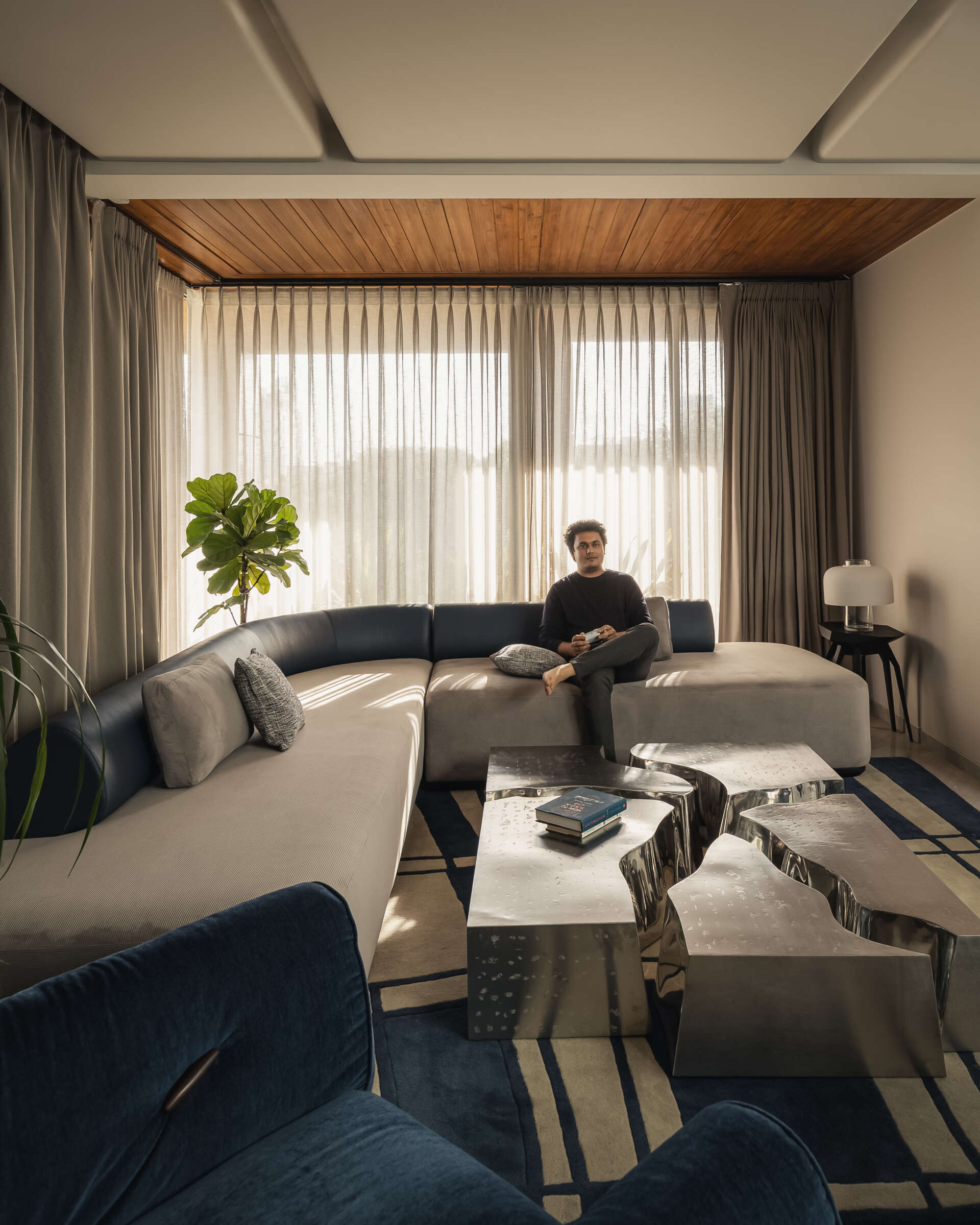 Up on the second floor, a den features one of the most unique elements in the house, a split table crafted in two different stainless steel finishes. As light and screen reflections shift, the table changes with it, creating a dynamic focal point.