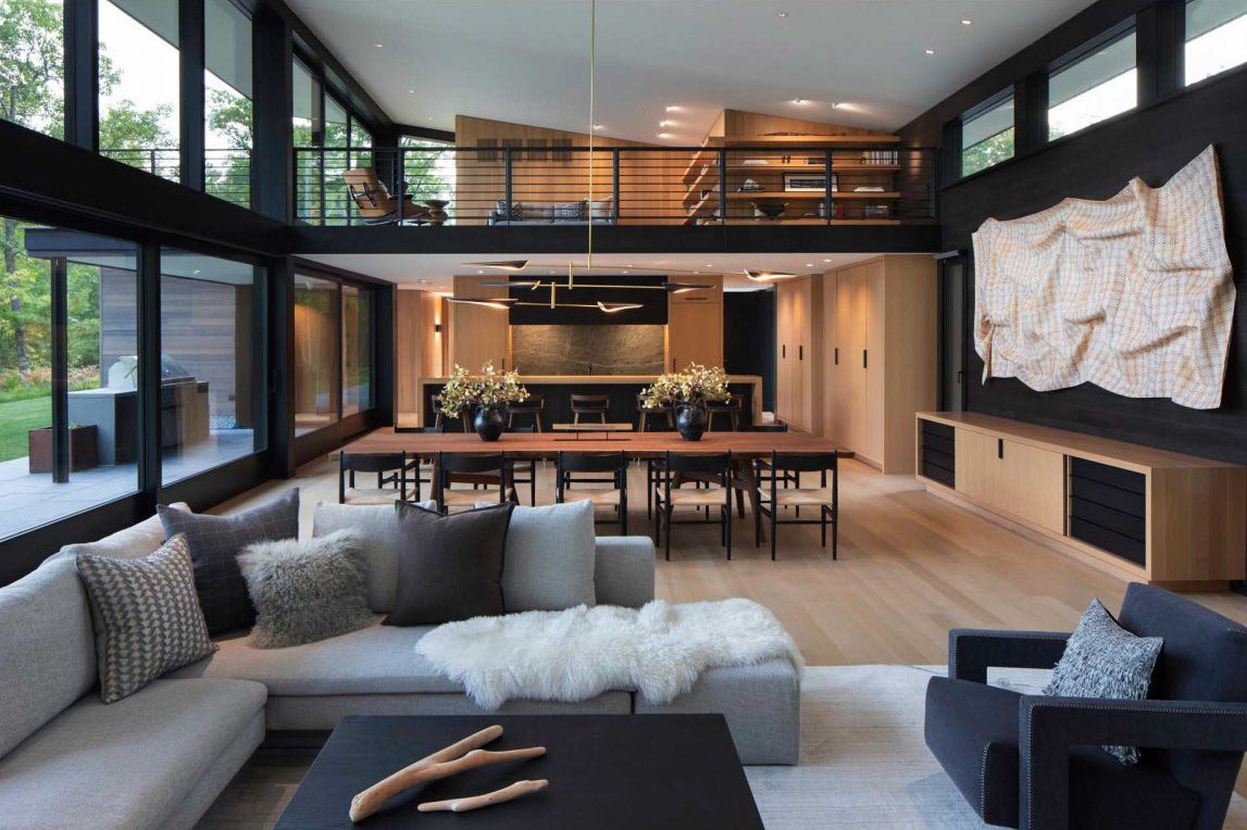 El luminoso salón cuenta con ventanales con vistas al lago y acceso perfecto a la terraza exterior y a la cocina.