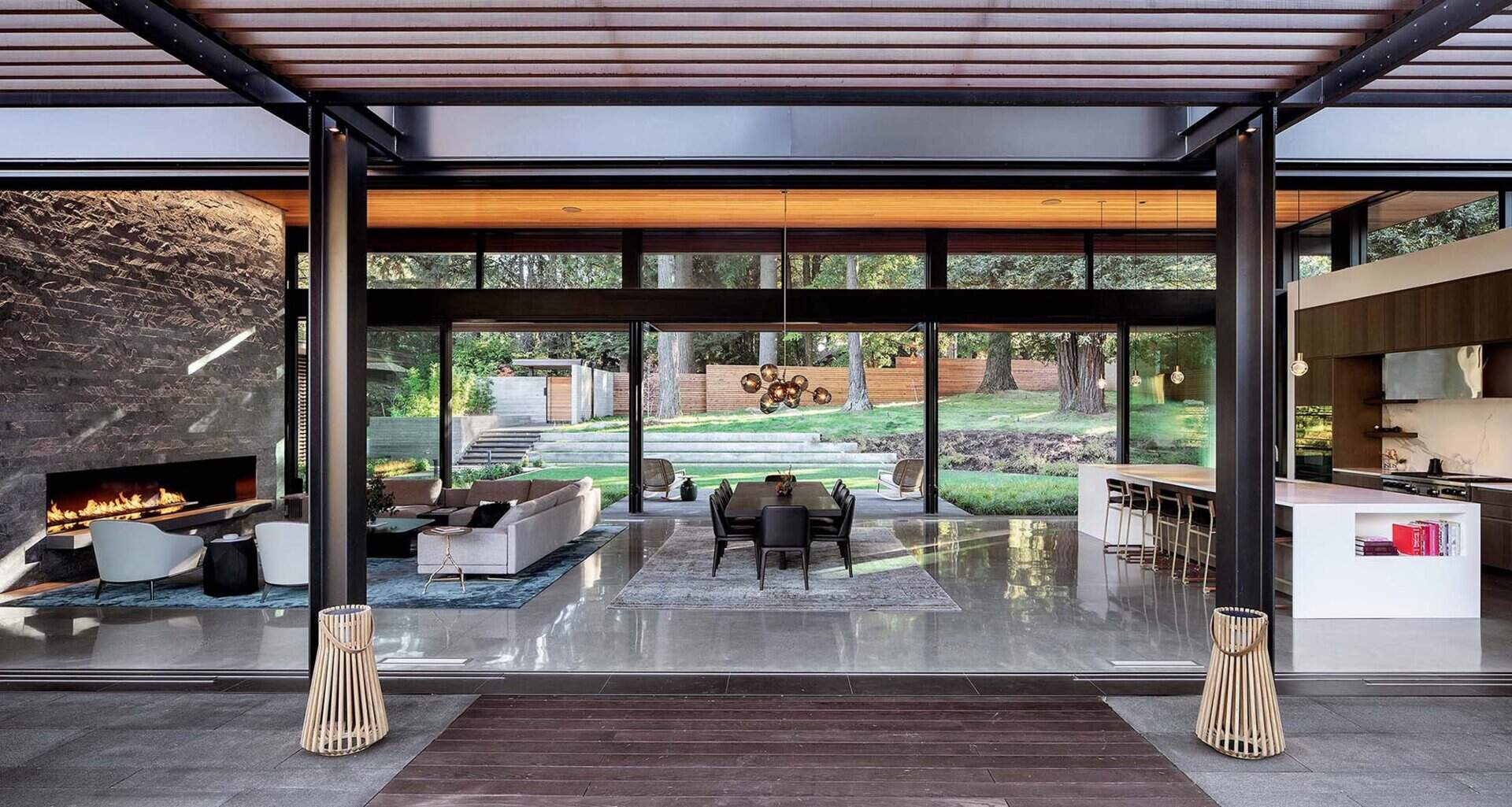 An open plan living space with retractable glass walls that fully connects to the outdoors. A seamless indoor outdoor layout perfect for entertaining.