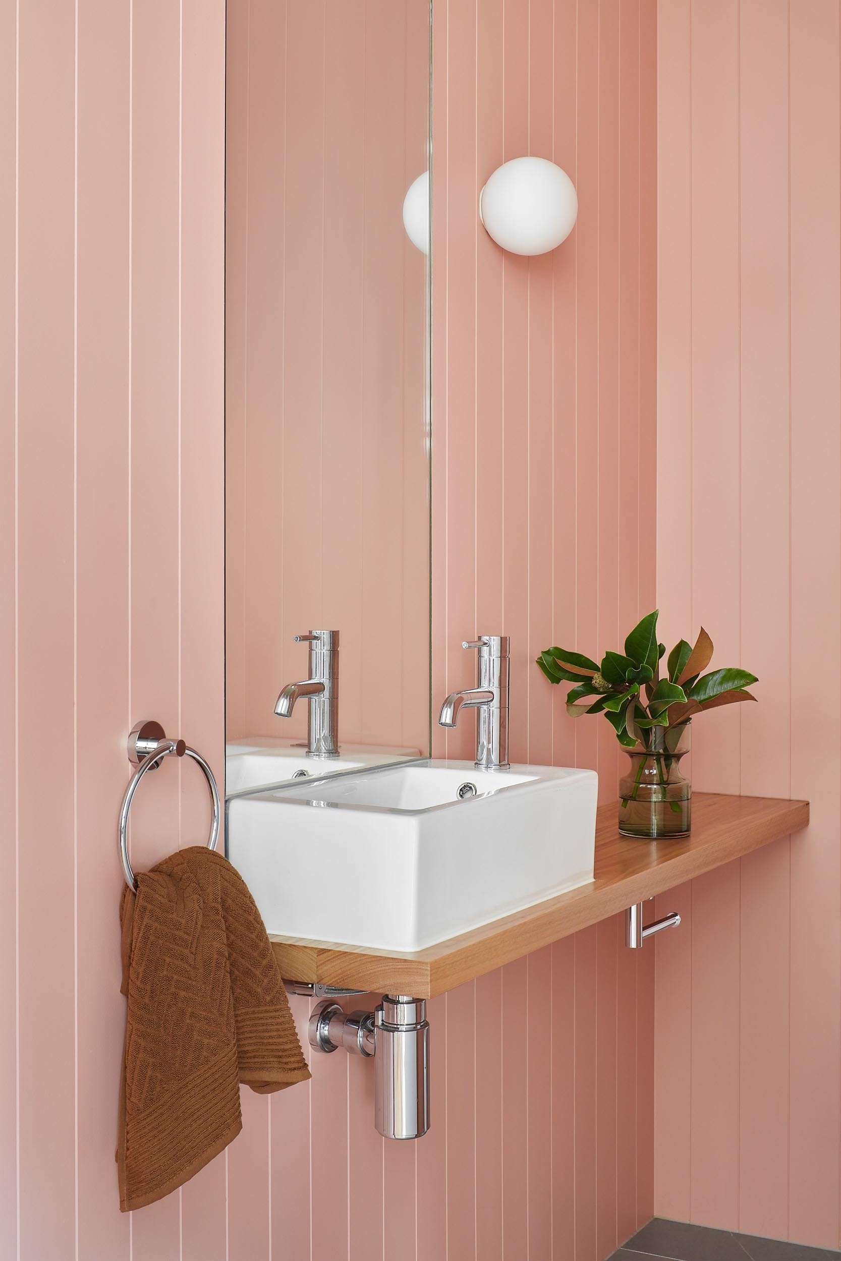 In this bathroom, soft pink walls introduce a gentle burst of color.
