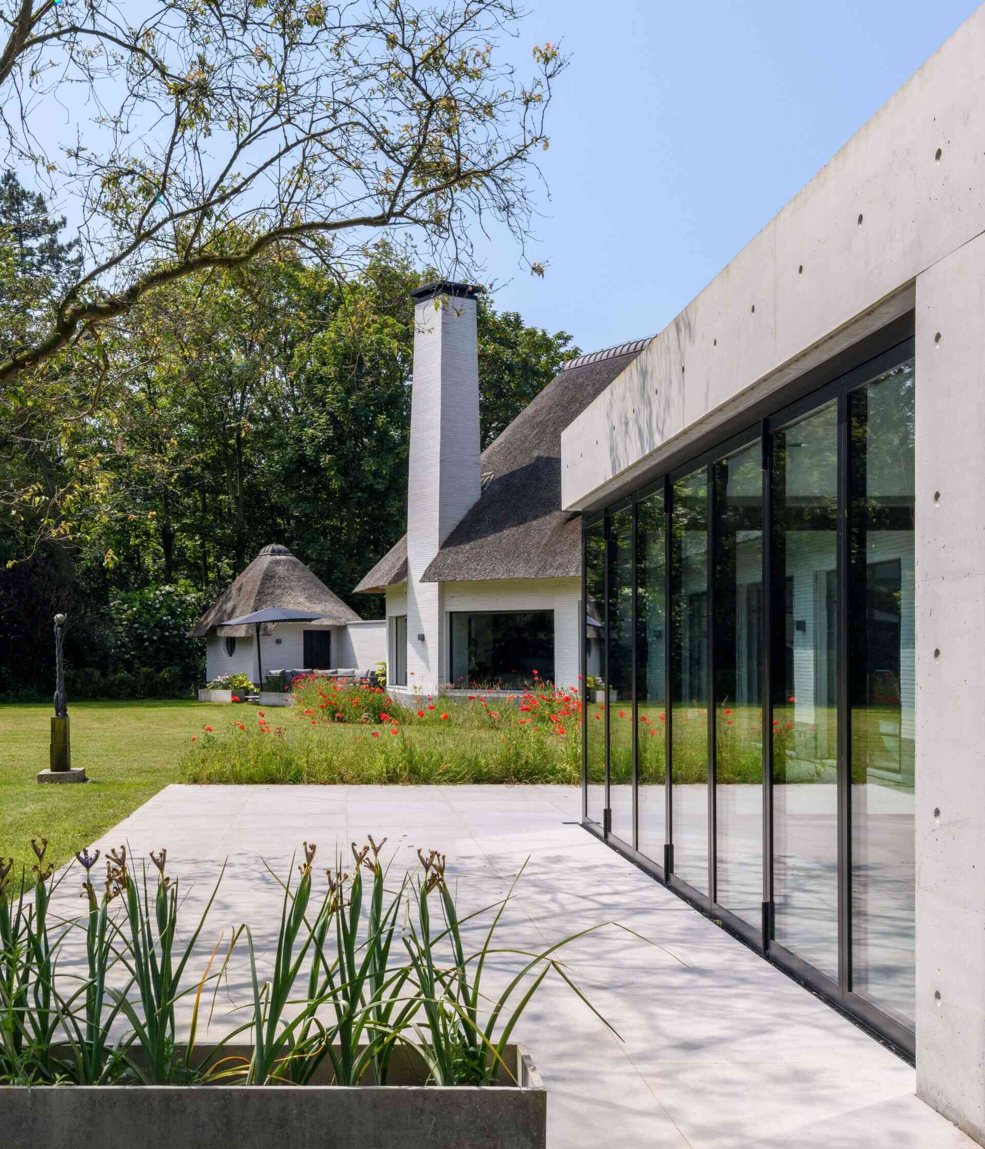 Llamativa extensión de bienestar con piscina, sauna y paredes de cristal plegables con acceso total a la terraza exterior.